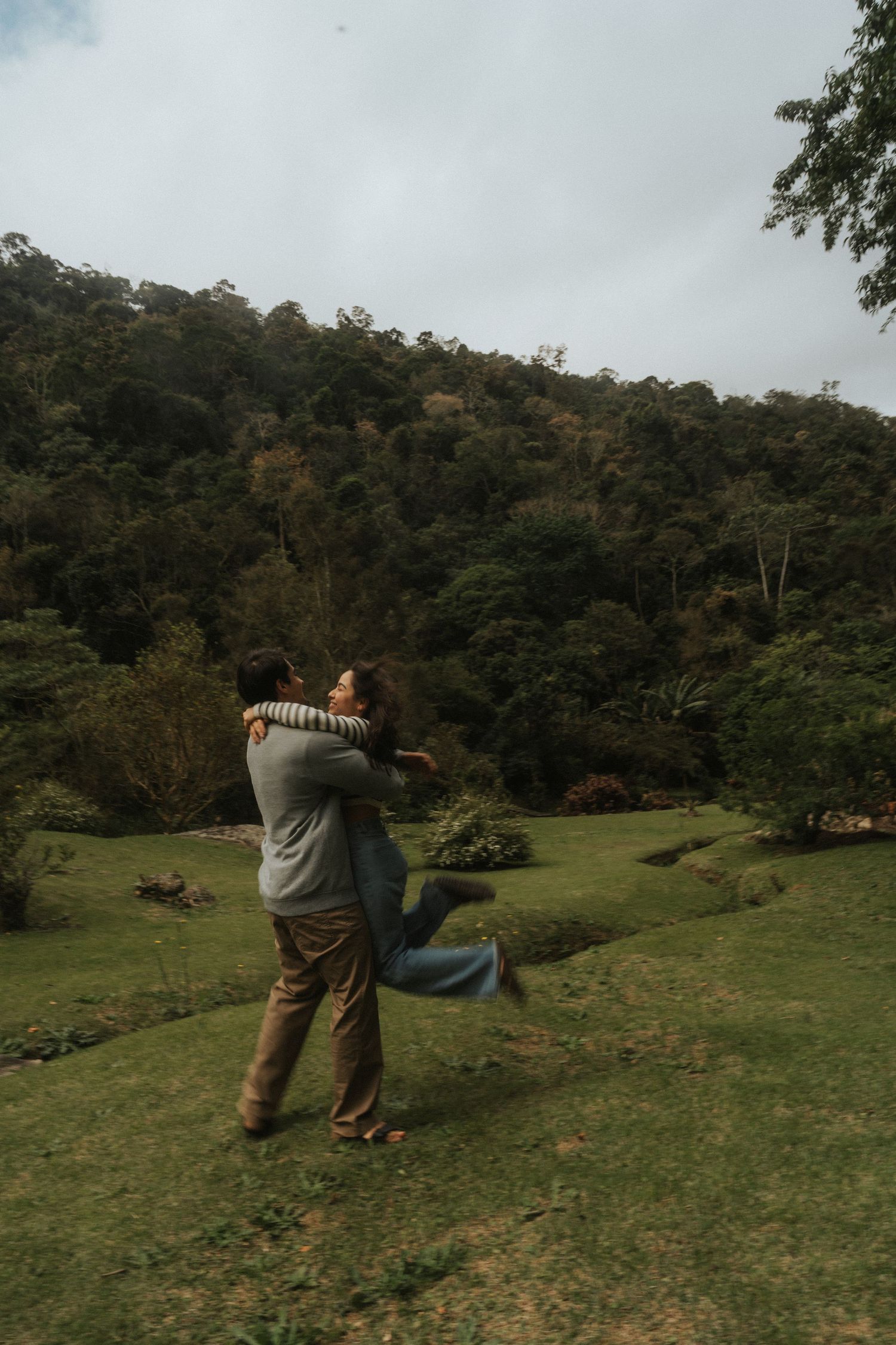 A sequence of images showing people practicing archery in a grassy field surrounded by forest on a cloudy day.