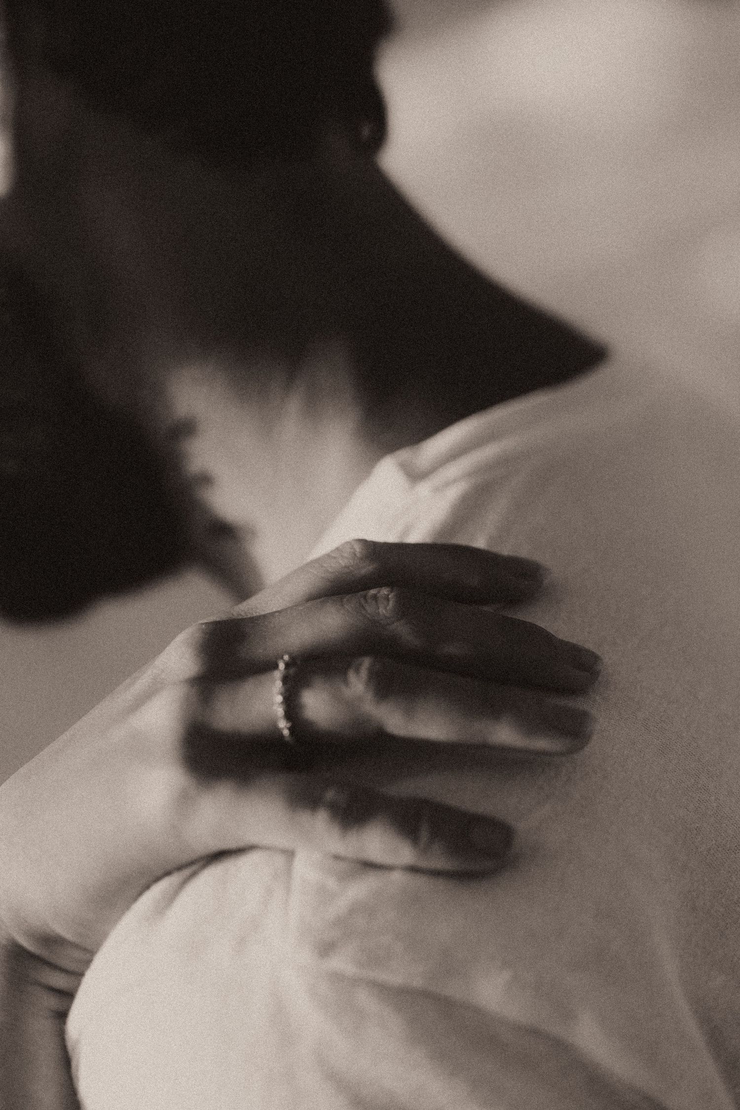 A dramatic black and white sequence of hands gliding across a white surface creating a flowing motion effect.