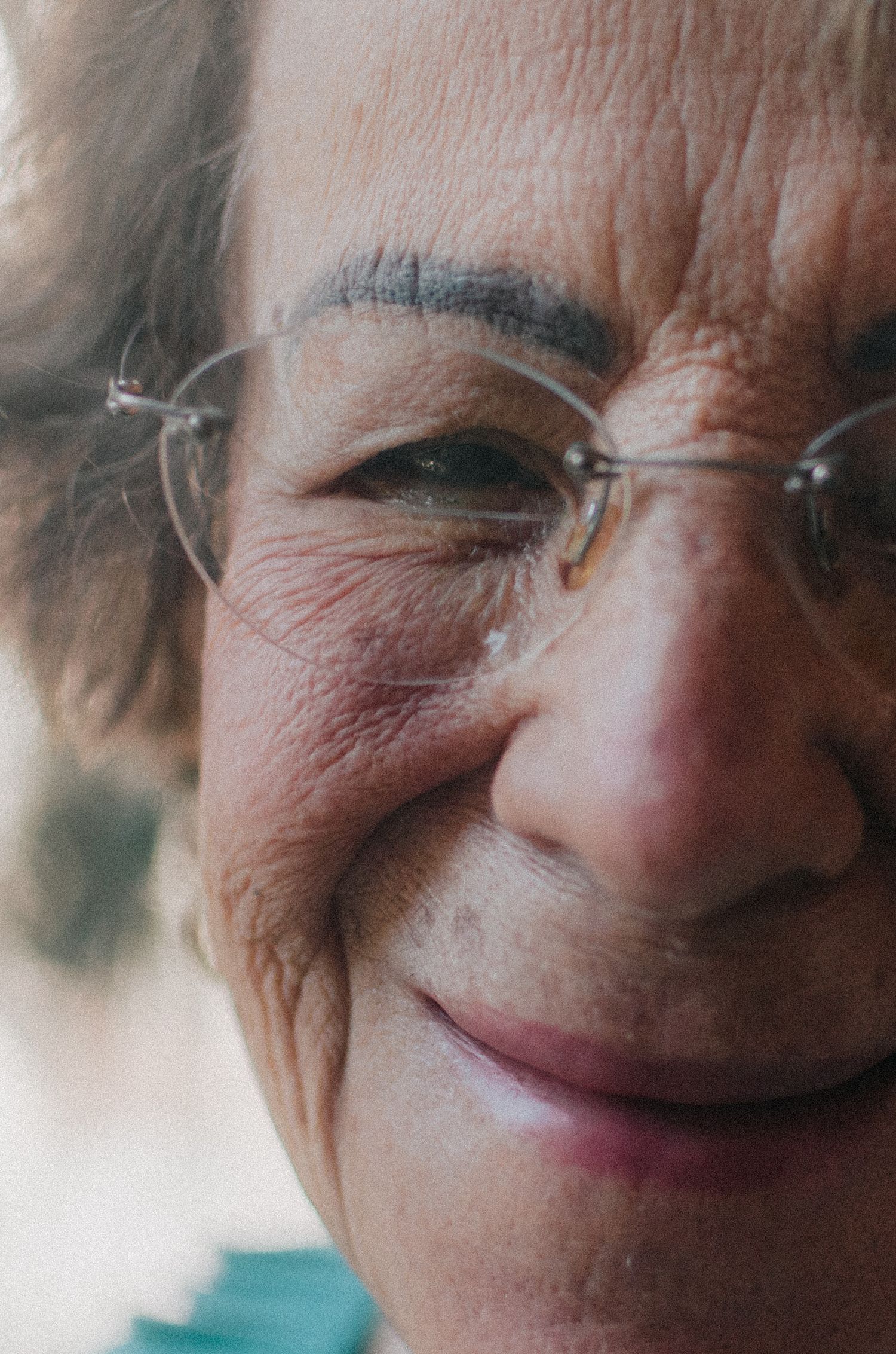 A series of close-up photos showing an elderly person's warm smile and laugh lines in sequence.