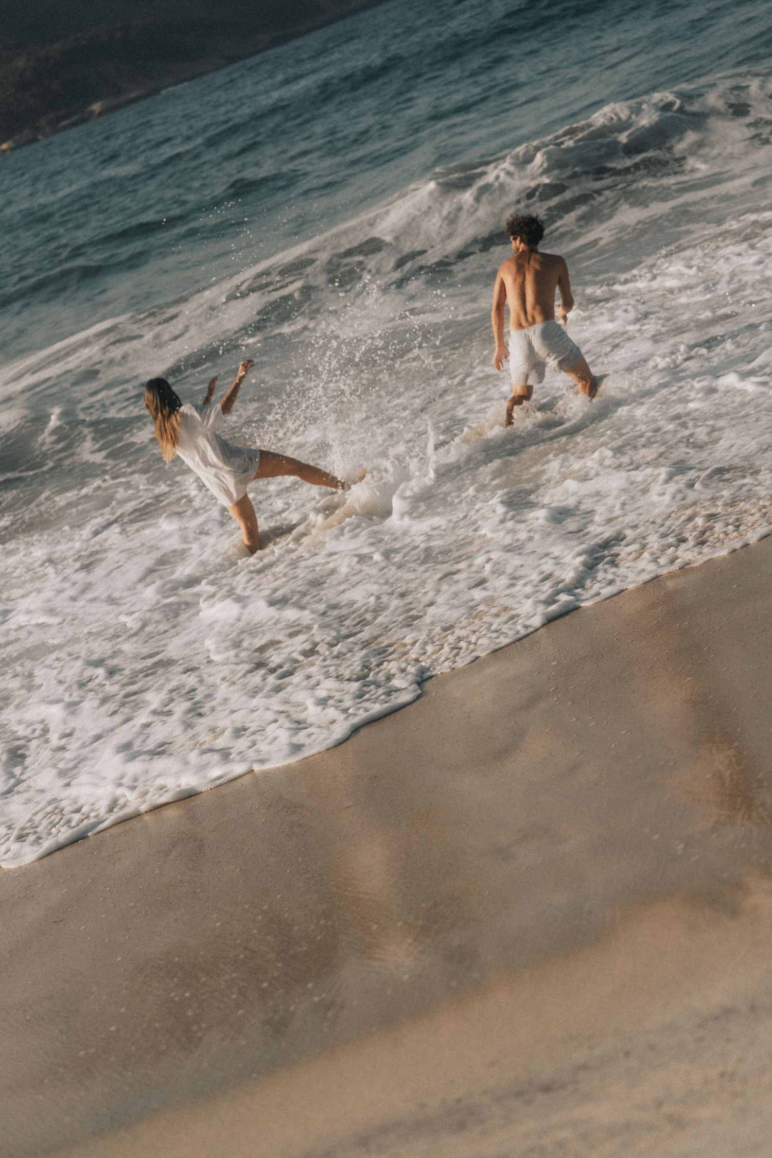 A sequence of photos showing someone running and jumping into ocean waves at a sandy beach during sunset.