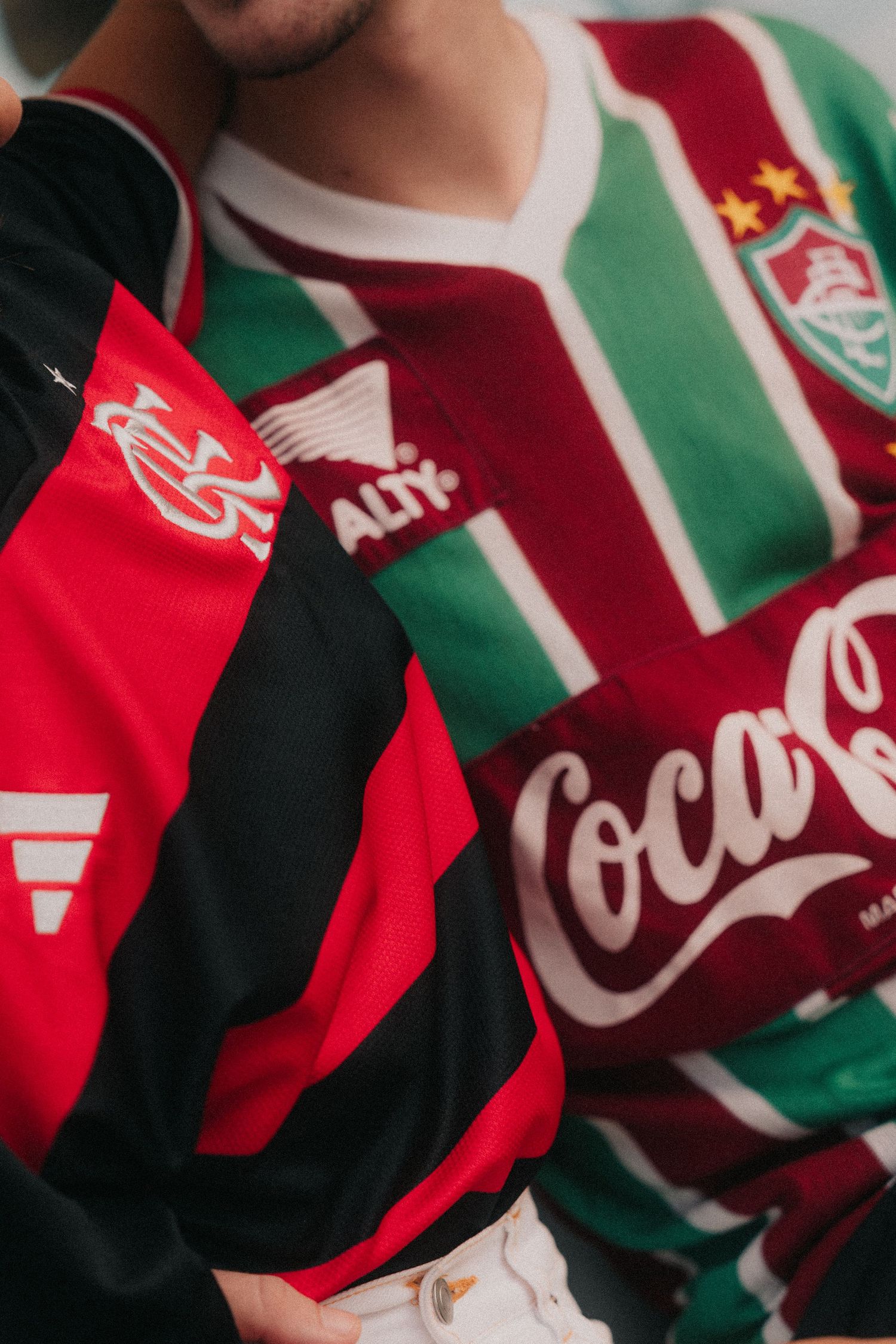 Several retro style sports jerseys with red, white and green stripes featuring Coca-Cola branding.