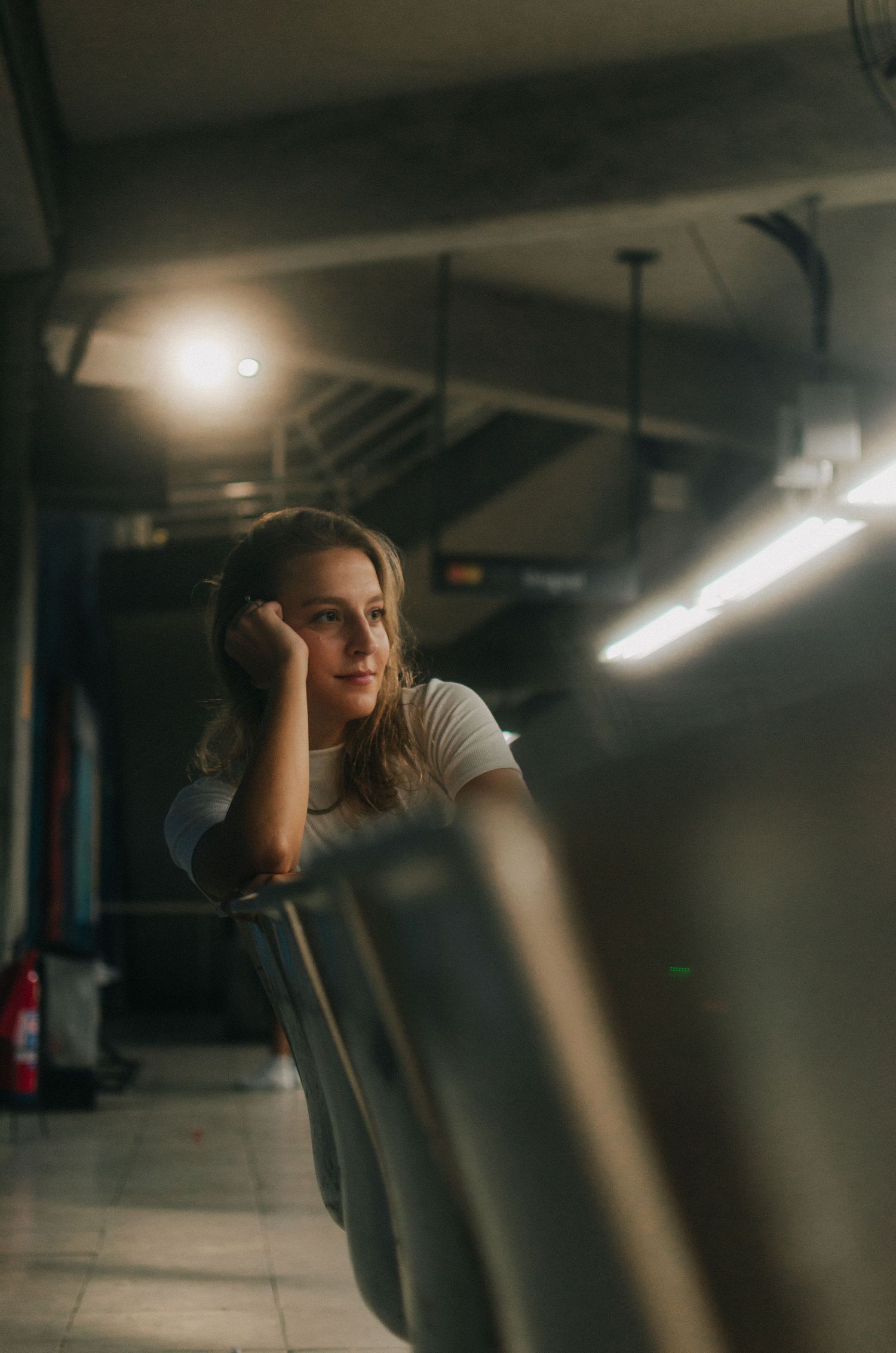 A person sits in dark moving train car while looking out window during an evocative moody journey.