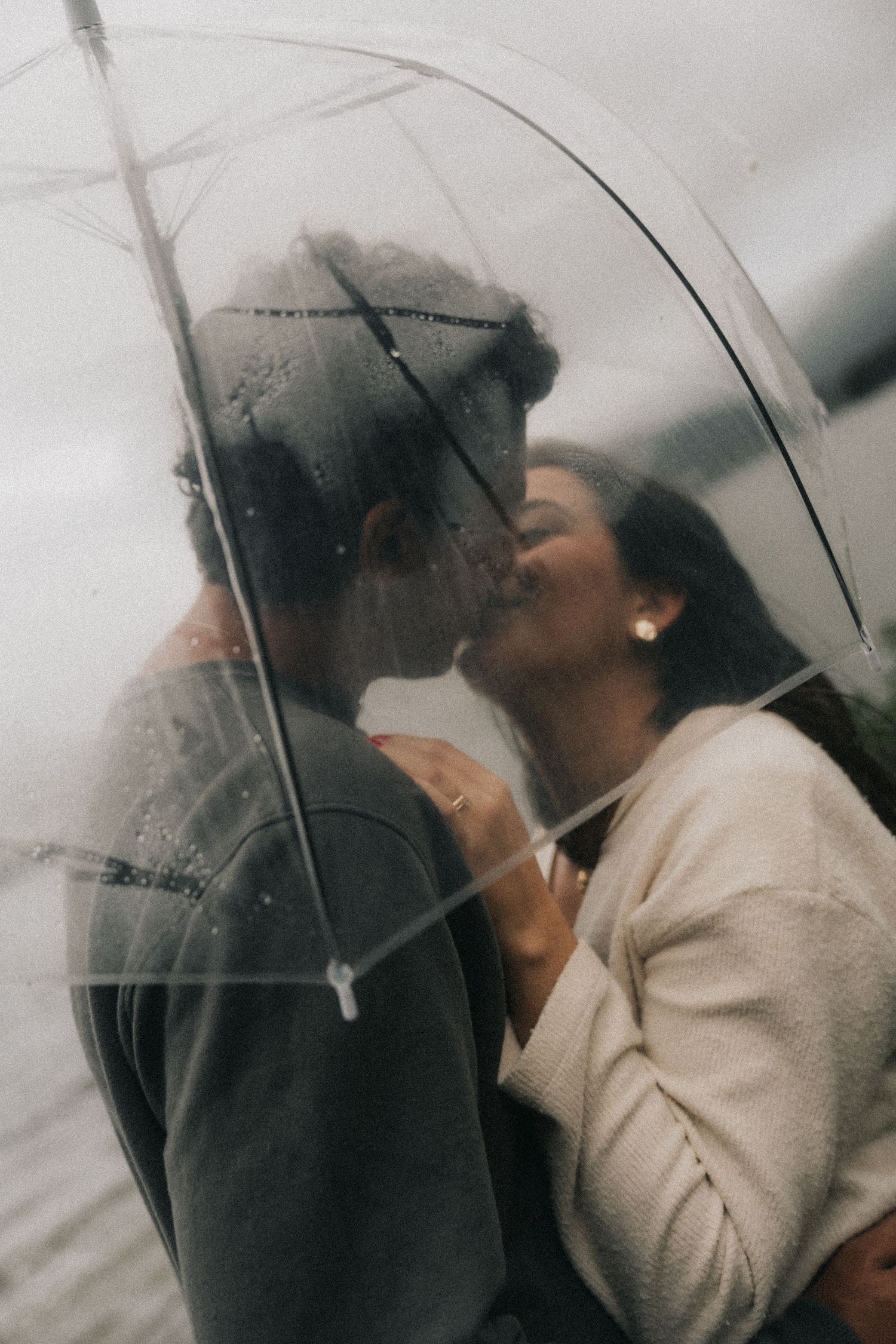 A dramatic black and white photo sequence shows figures behind glass with water droplets creating a moody atmospheric effect.