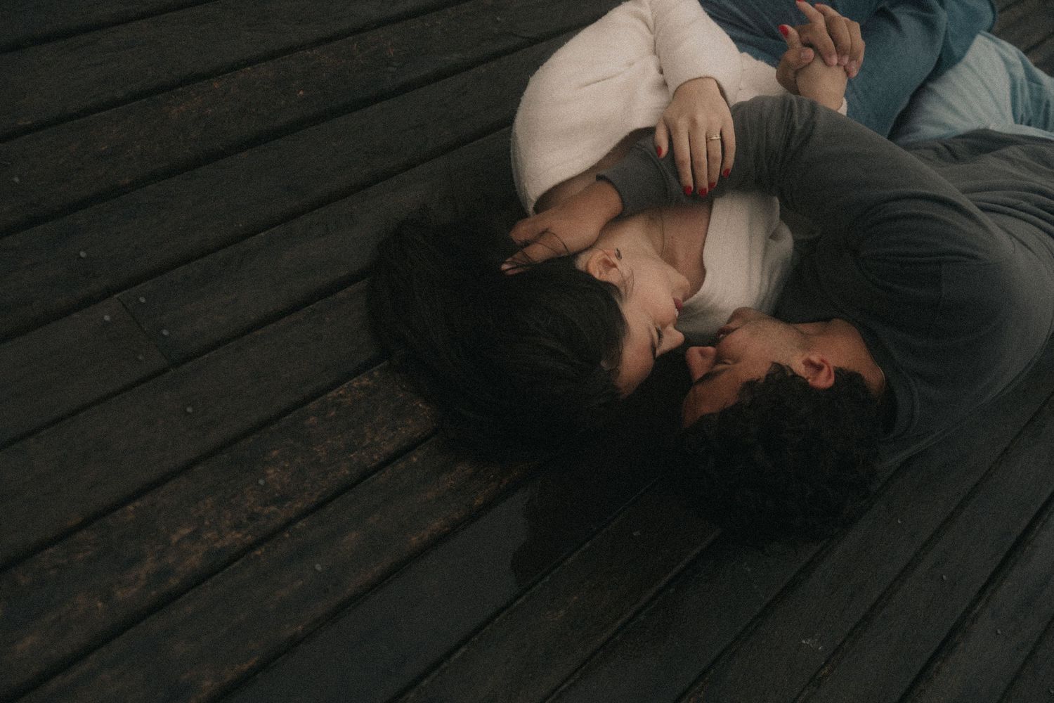 A collage of six romantic photos shows a couple sharing tender moments on a wooden floor.