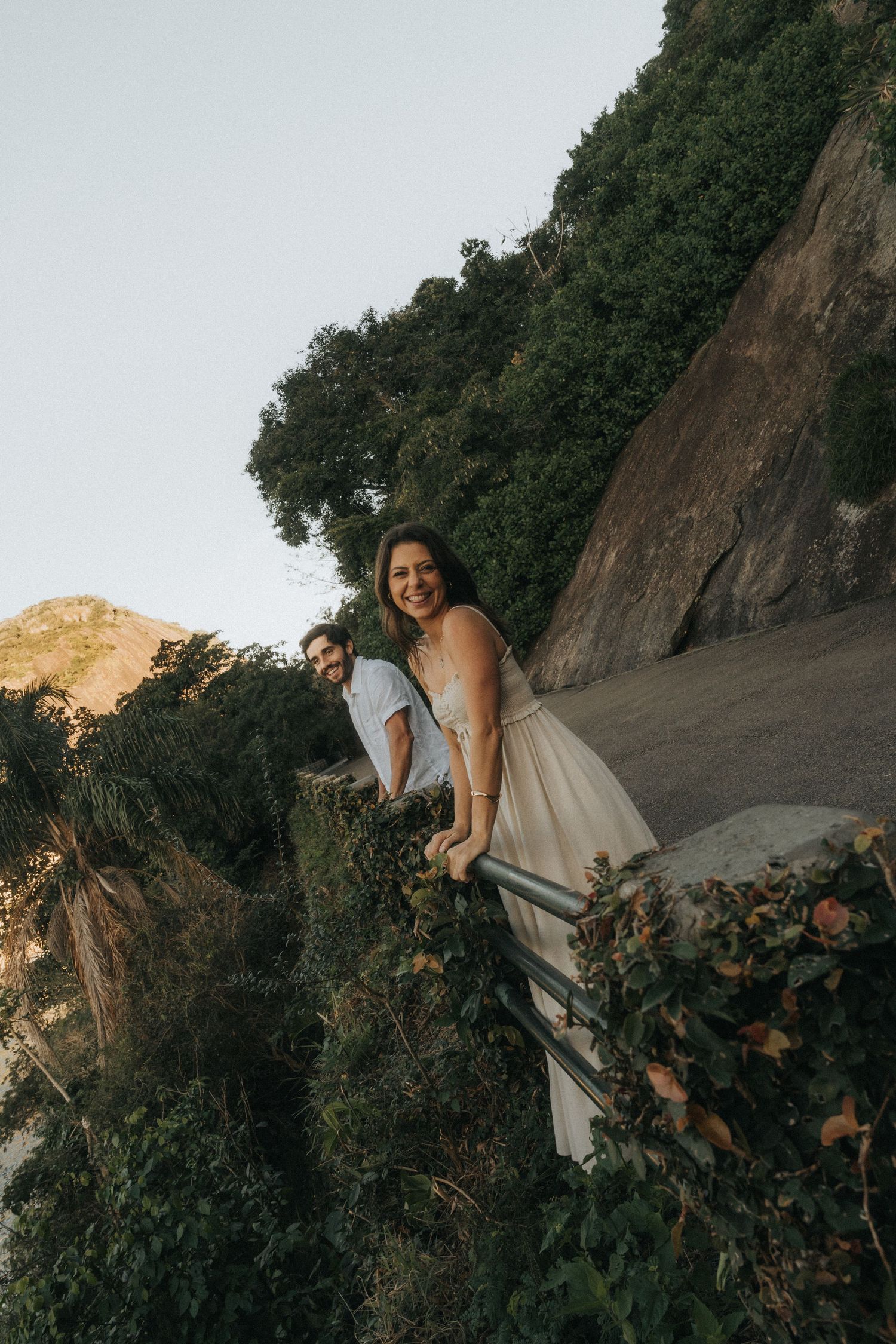 Person in flowing white dress explores lush mountainous terrain during golden hour lighting in sequential photos.