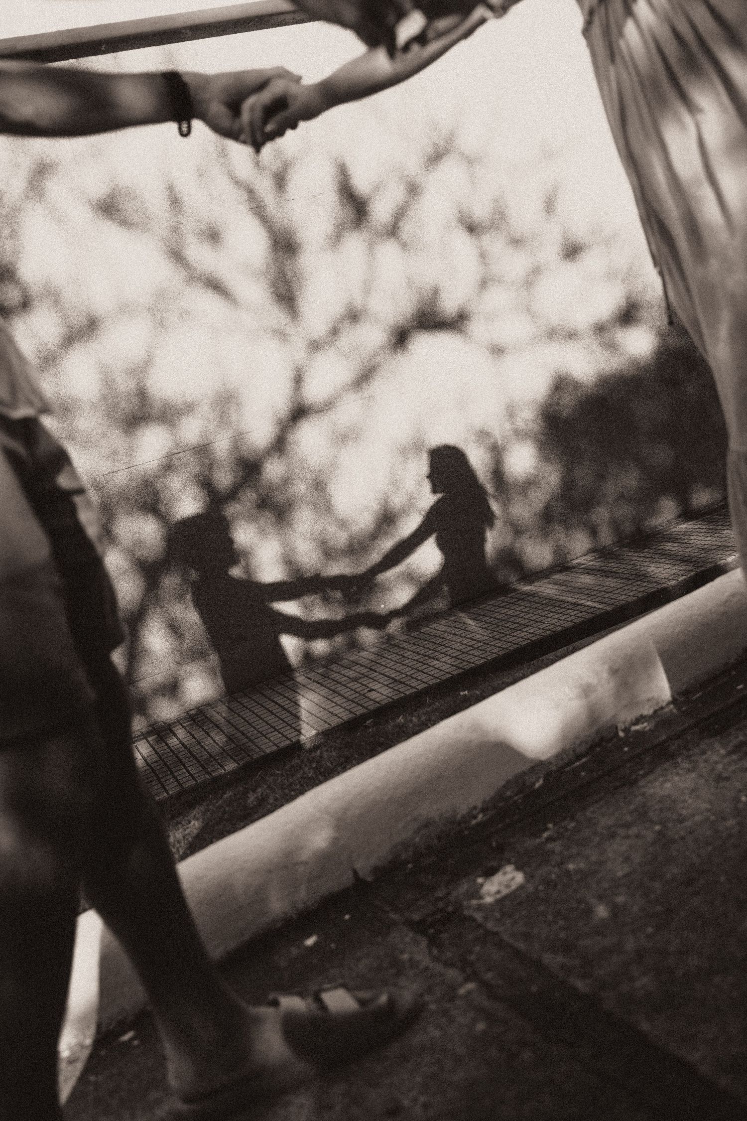 Motion-blurred black and white sequence showing hands using grater or grilling utensils on outdoor cookware.