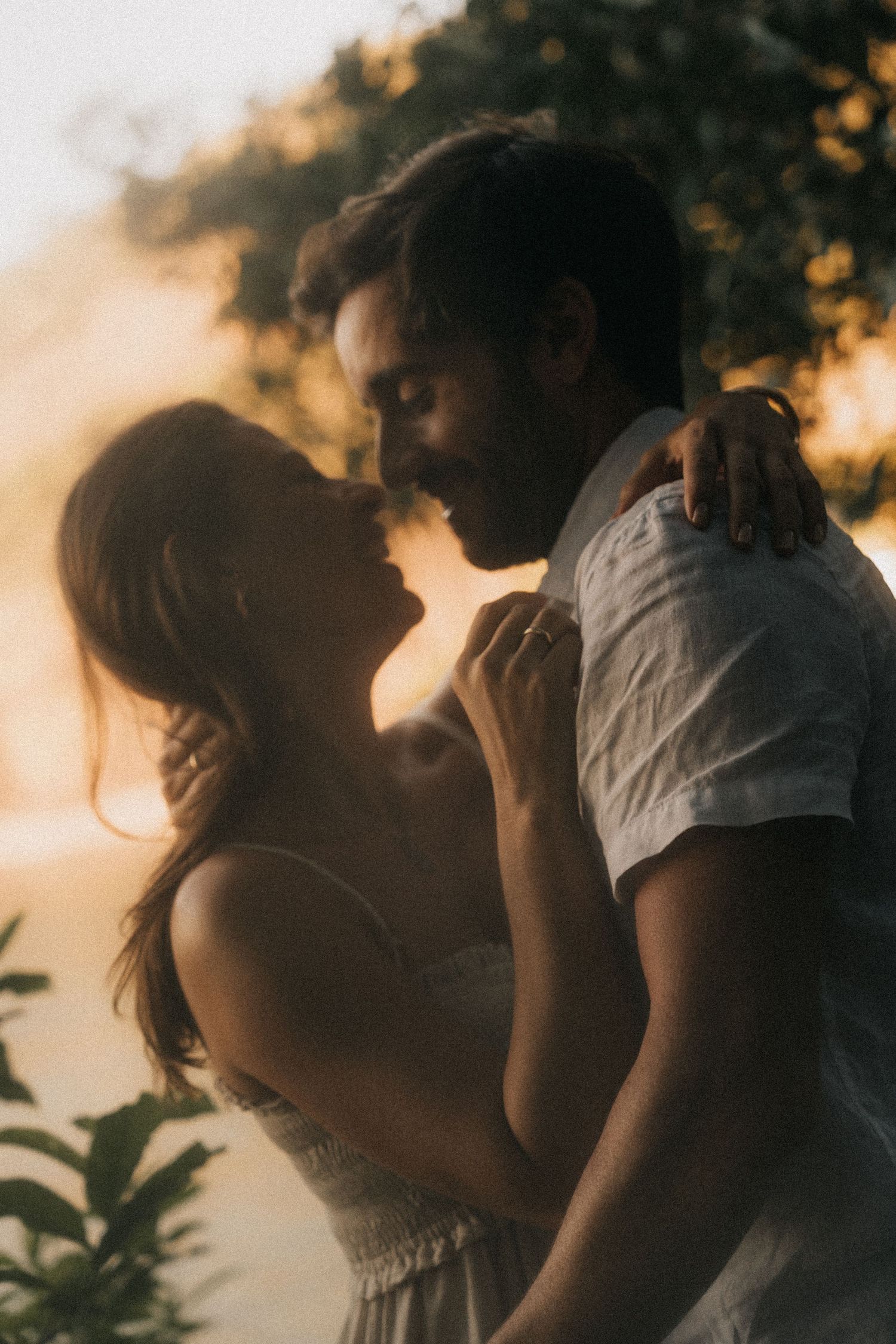 Silhouetted figures embrace romantically during golden sunset hour in an artistic sequence of four connected images.