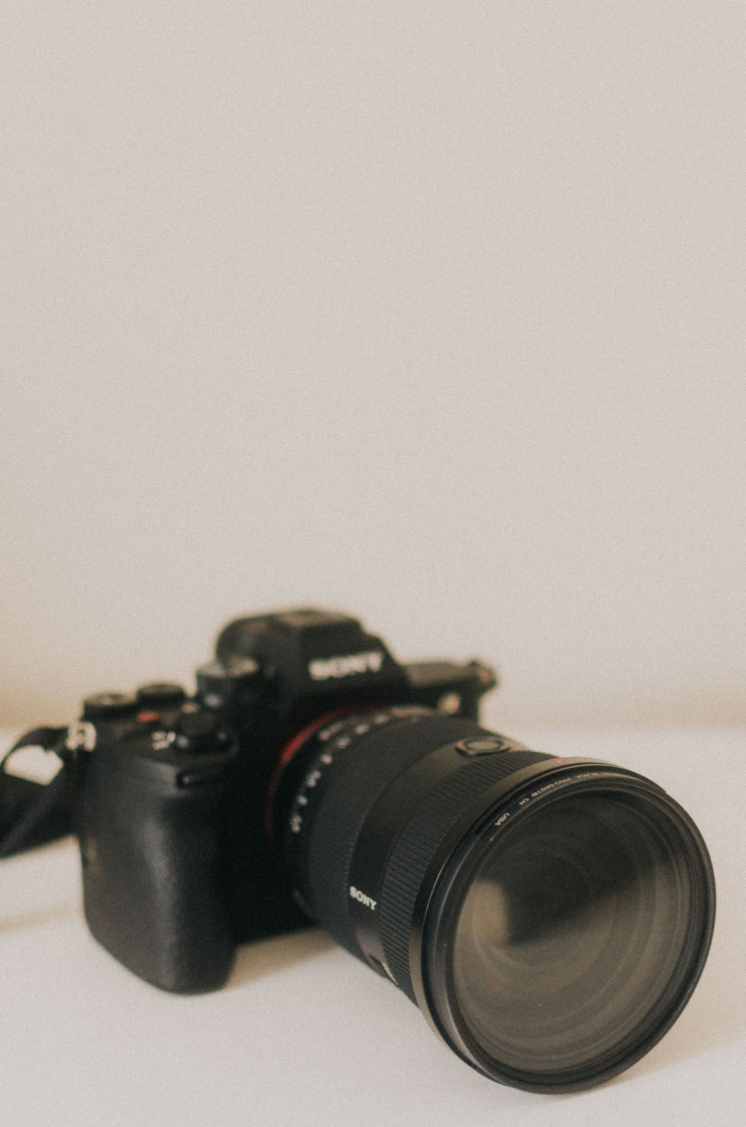 Professional black camera with telephoto lens displayed from different angles.