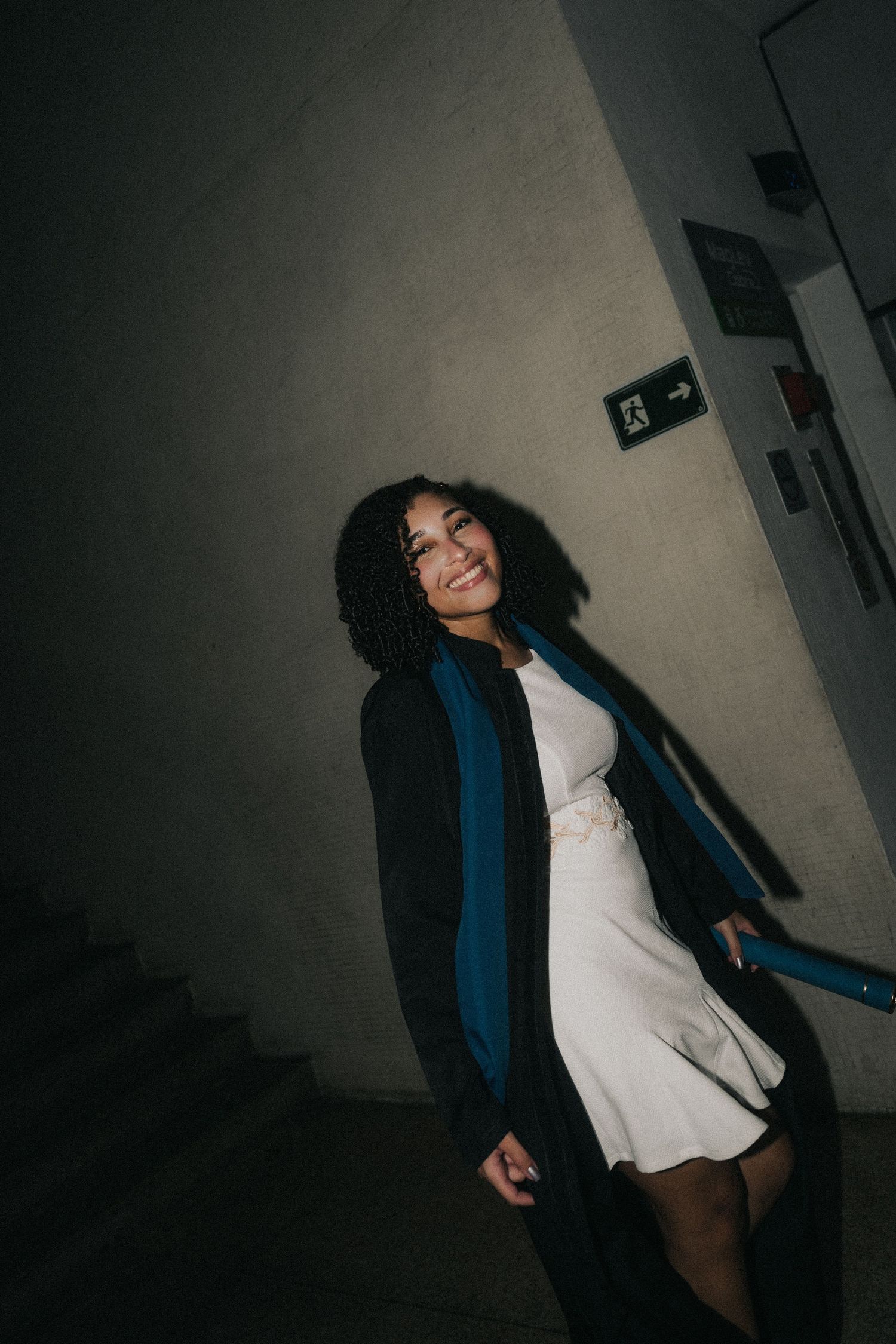 A person in a dark coat and white shirt poses in a dimly lit hallway creating a series of cinematic silhouettes.