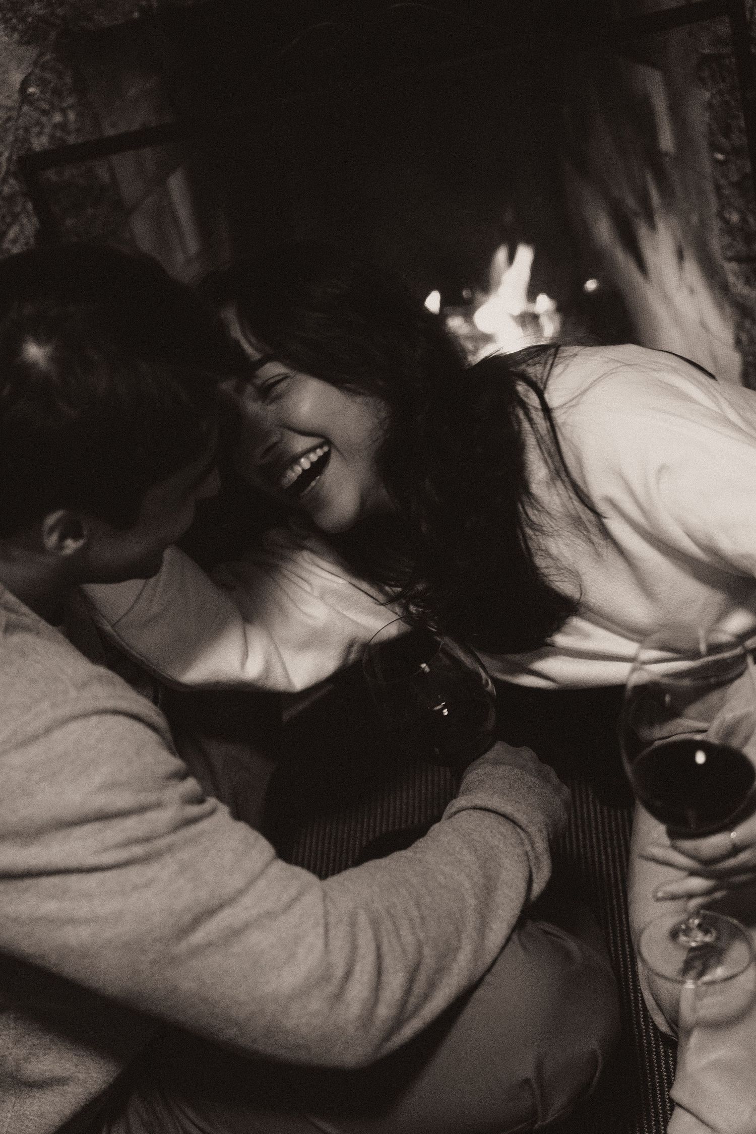 Black and white artistic photograph showing two figures in an intimate embrace on a couch.