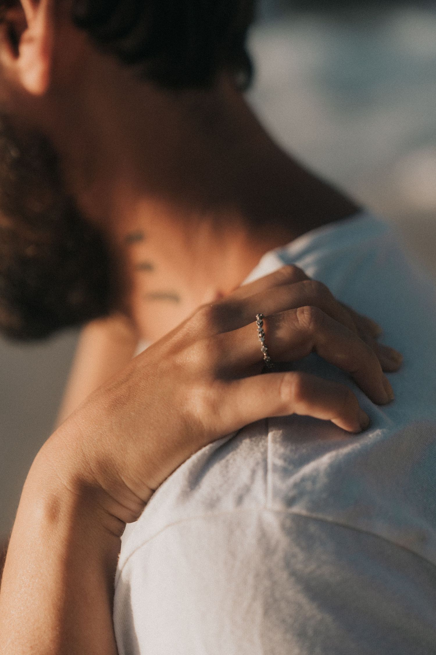 Person massaging their own neck and shoulder area to relieve tension and stress against a blurred background.