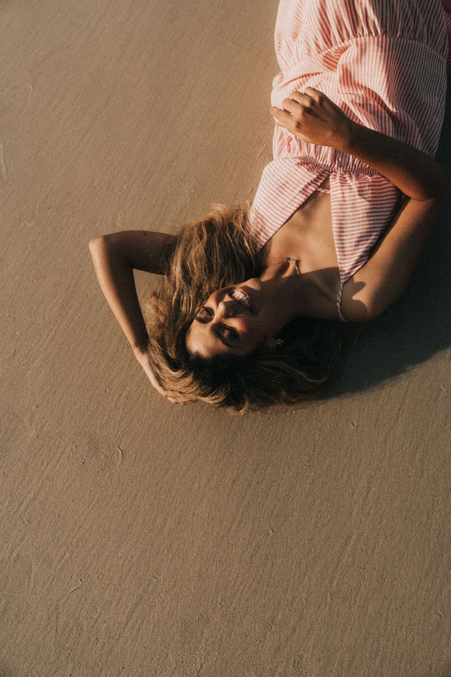 A sequence of artistic photos showing a person in pink laying down on a beige carpet from different angles.
