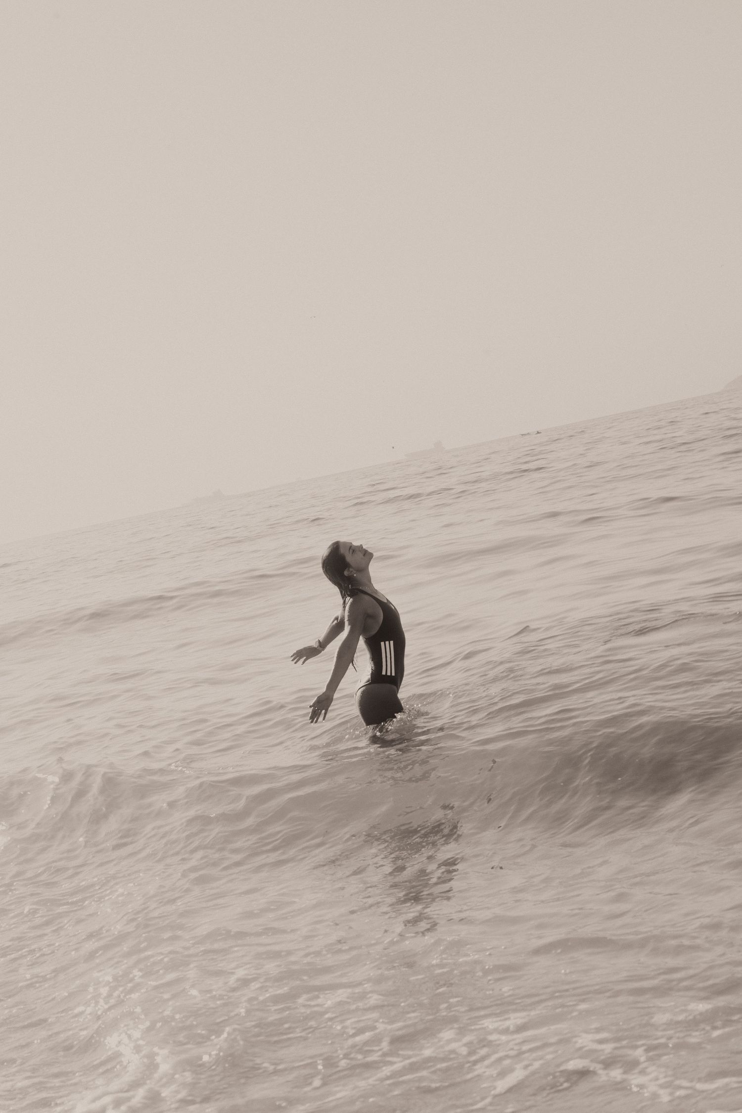 A sequence of vintage photos shows a person diving and swimming in ocean waves creating a graceful motion study.