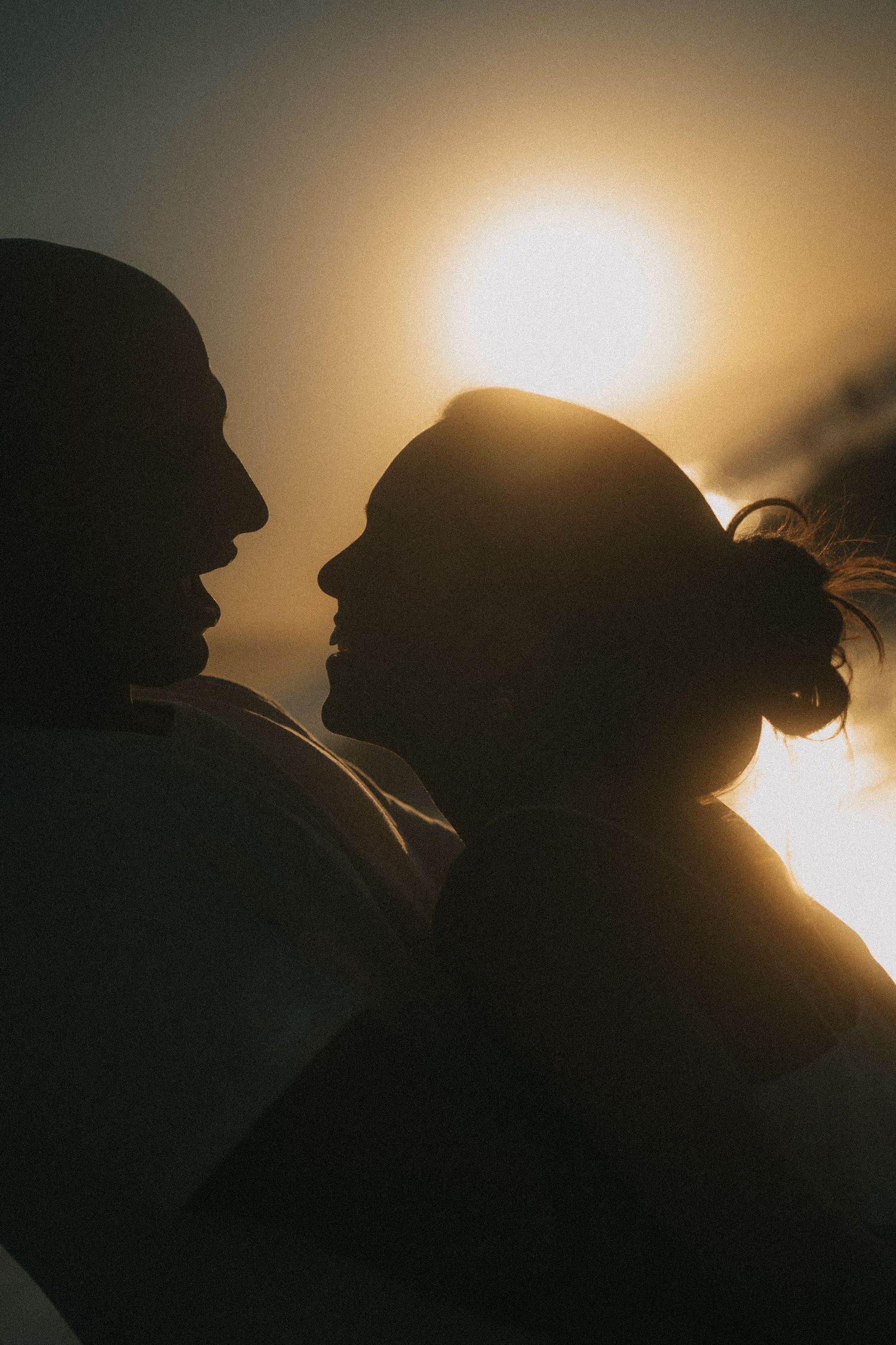 A silhouetted figure against warm sunlight creates a dramatic backlit portrait in a golden-hour lighting sequence.