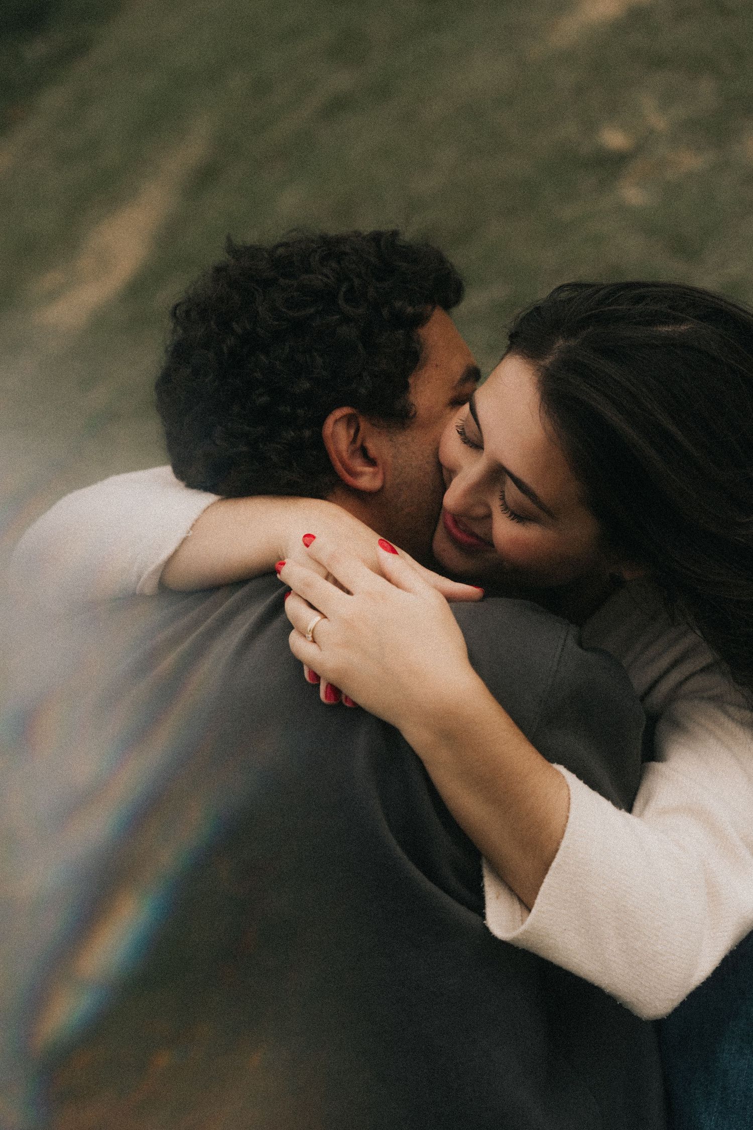 Two people embrace in a tender moment showing deep emotional connection in moody lighting.