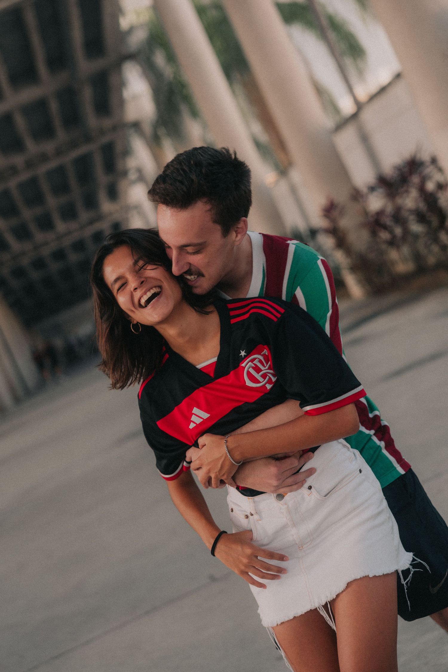 A couple embracing and laughing while wearing soccer jerseys in a series of candid moments.