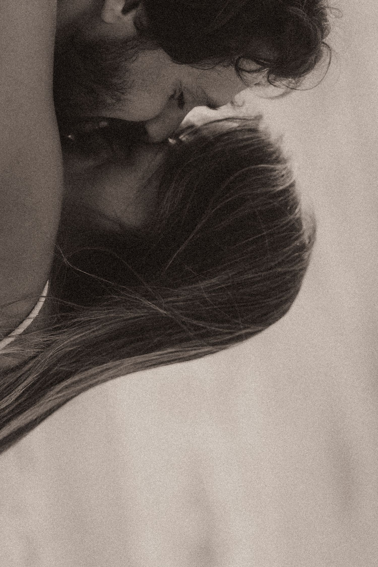 A close up black and white silhouette of two people intimately kissing showing their profiles.