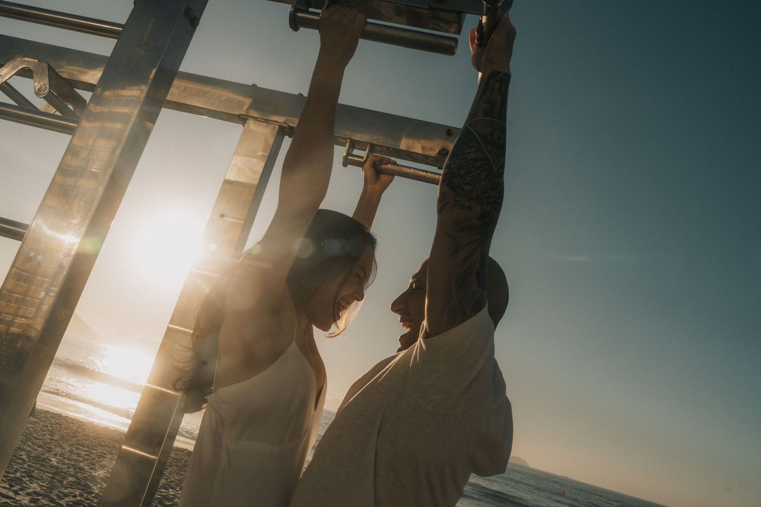 Silhouettes of people standing against a bright sunset streaming through office windows during golden hour.