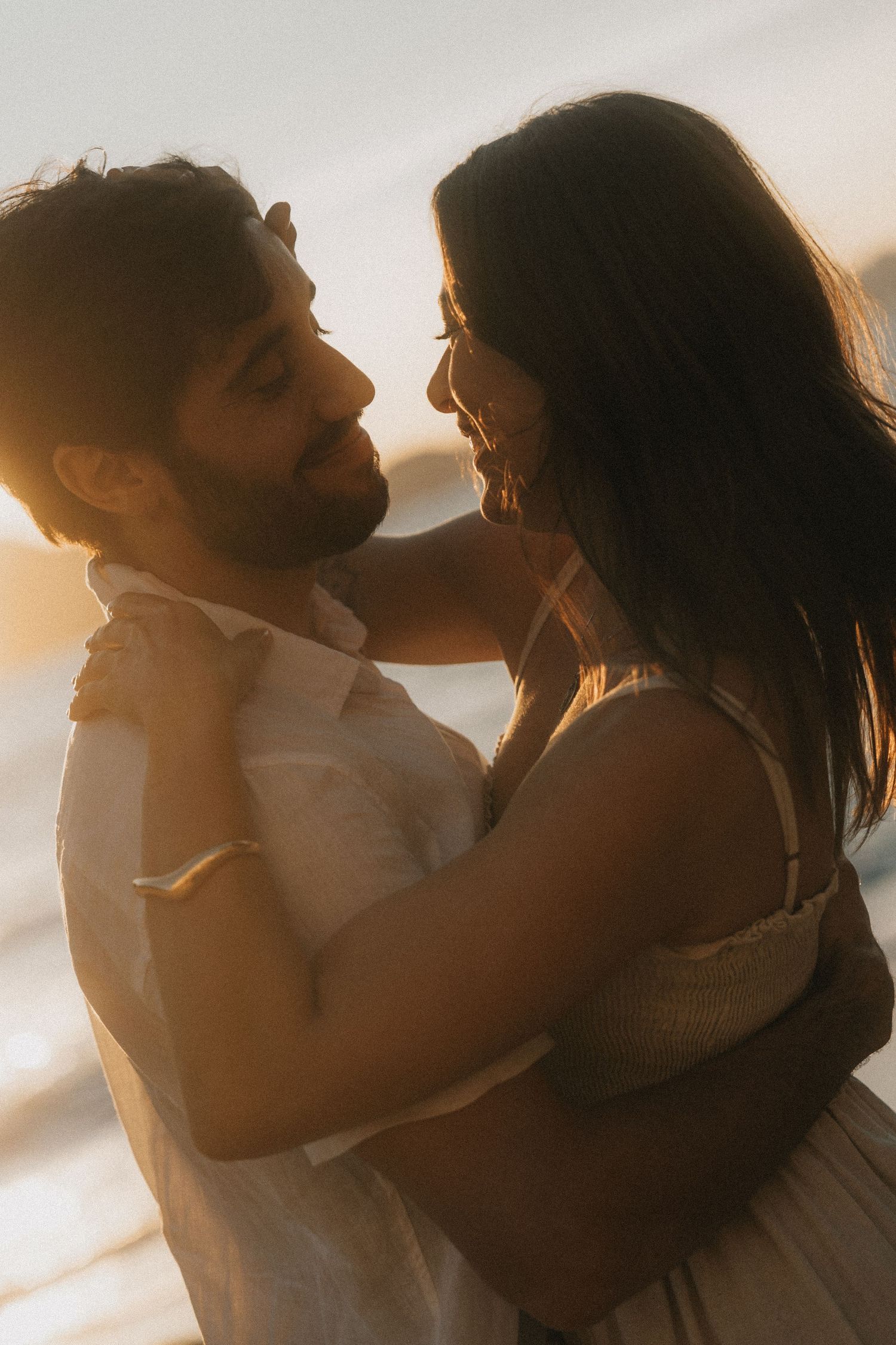 A romantic silhouetted couple embraces intimately against a warm sunset backdrop in a series of tender moments.