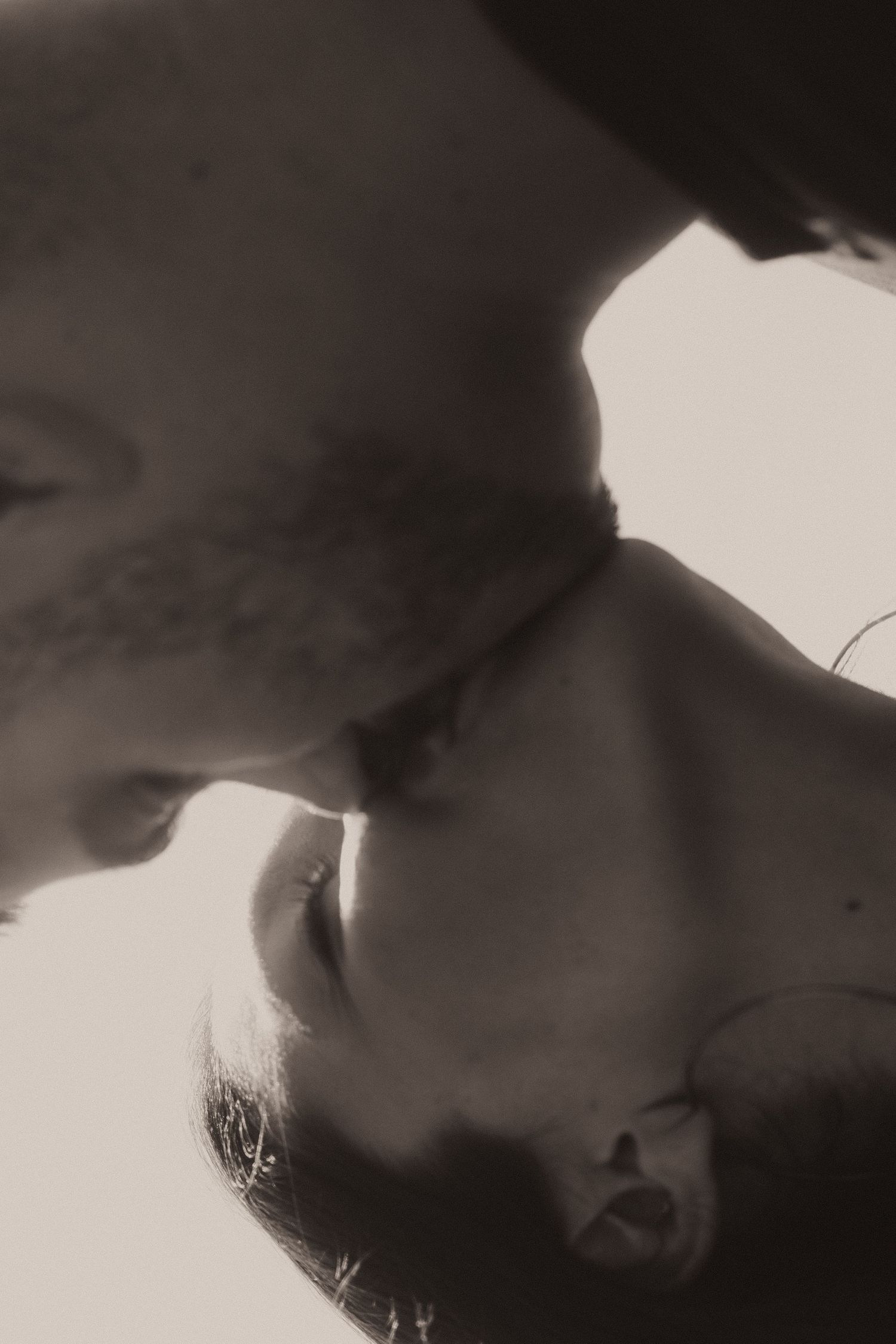 Close-up black and white images showing silhouetted human figures in an intimate artistic composition.