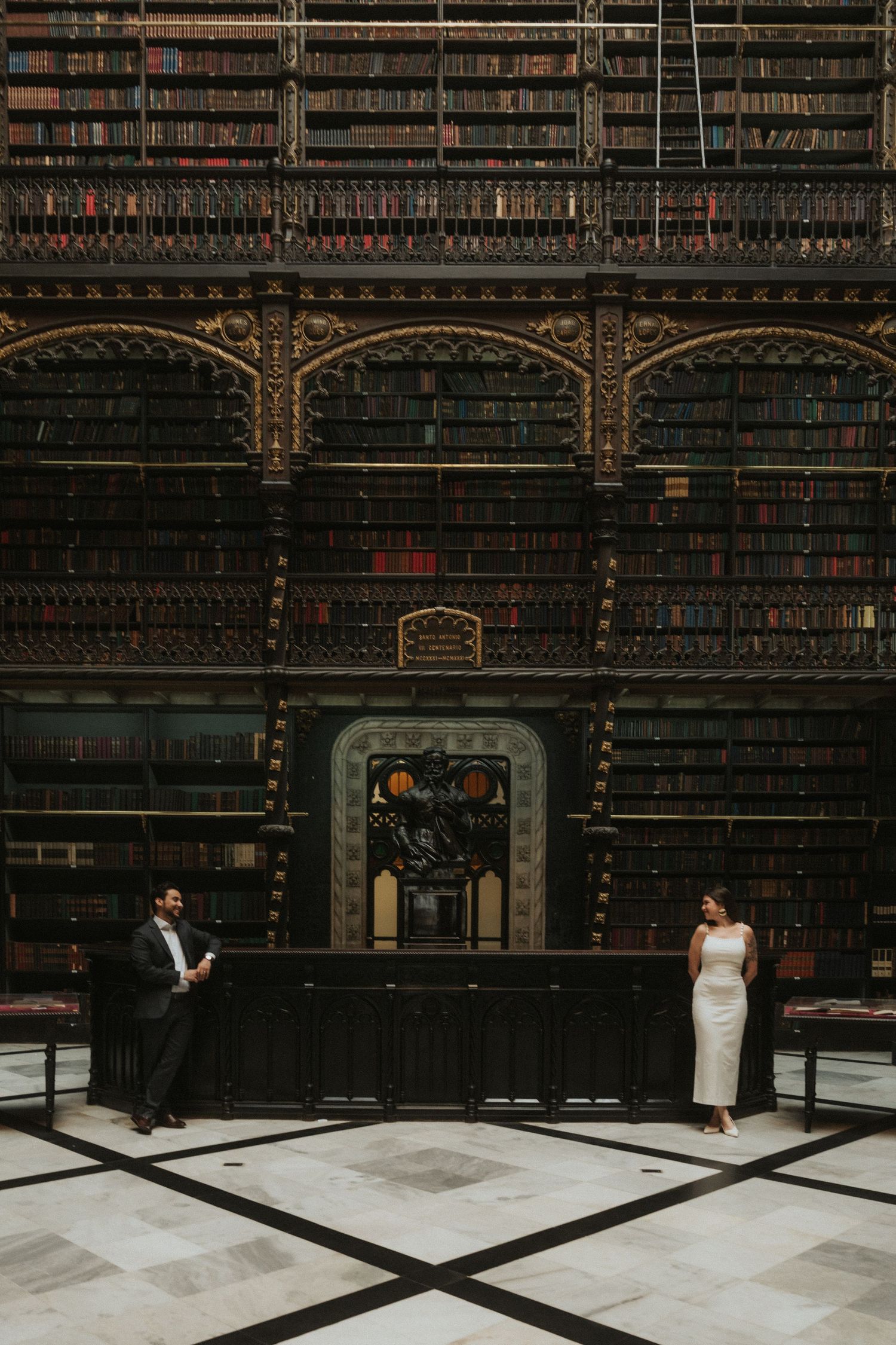 A series of five photos showing a bride in a white dress against dark wooden bookshelves in an ornate historic library.