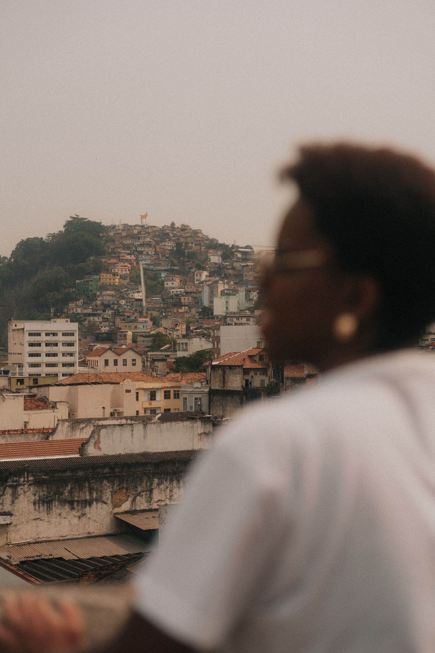 Urban cityscape view of hillside neighborhood with dense buildings and overcast sky in Brazil.