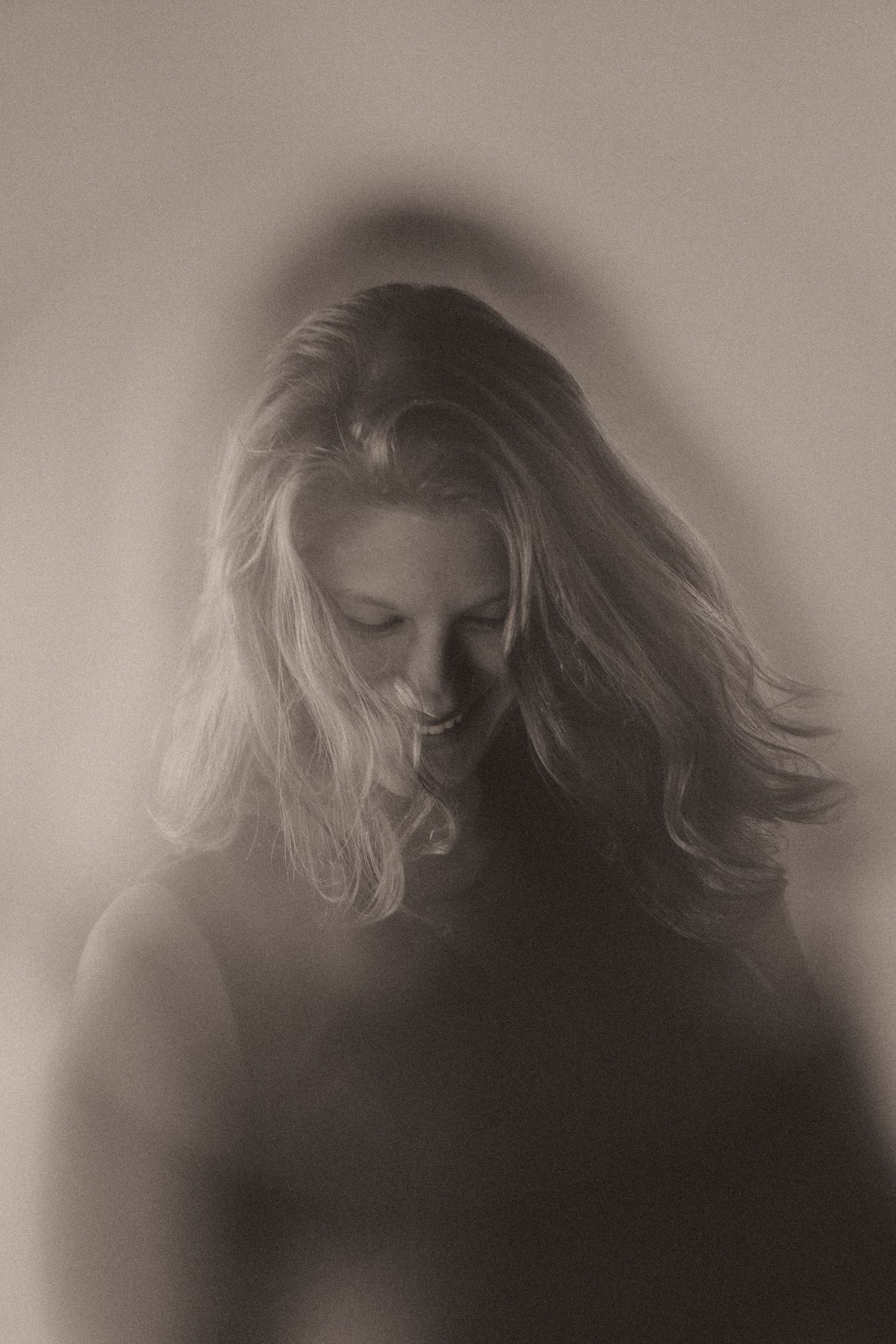 A series of black and white photographs showing a figure with flowing hair in motion with a dreamy, ethereal quality.