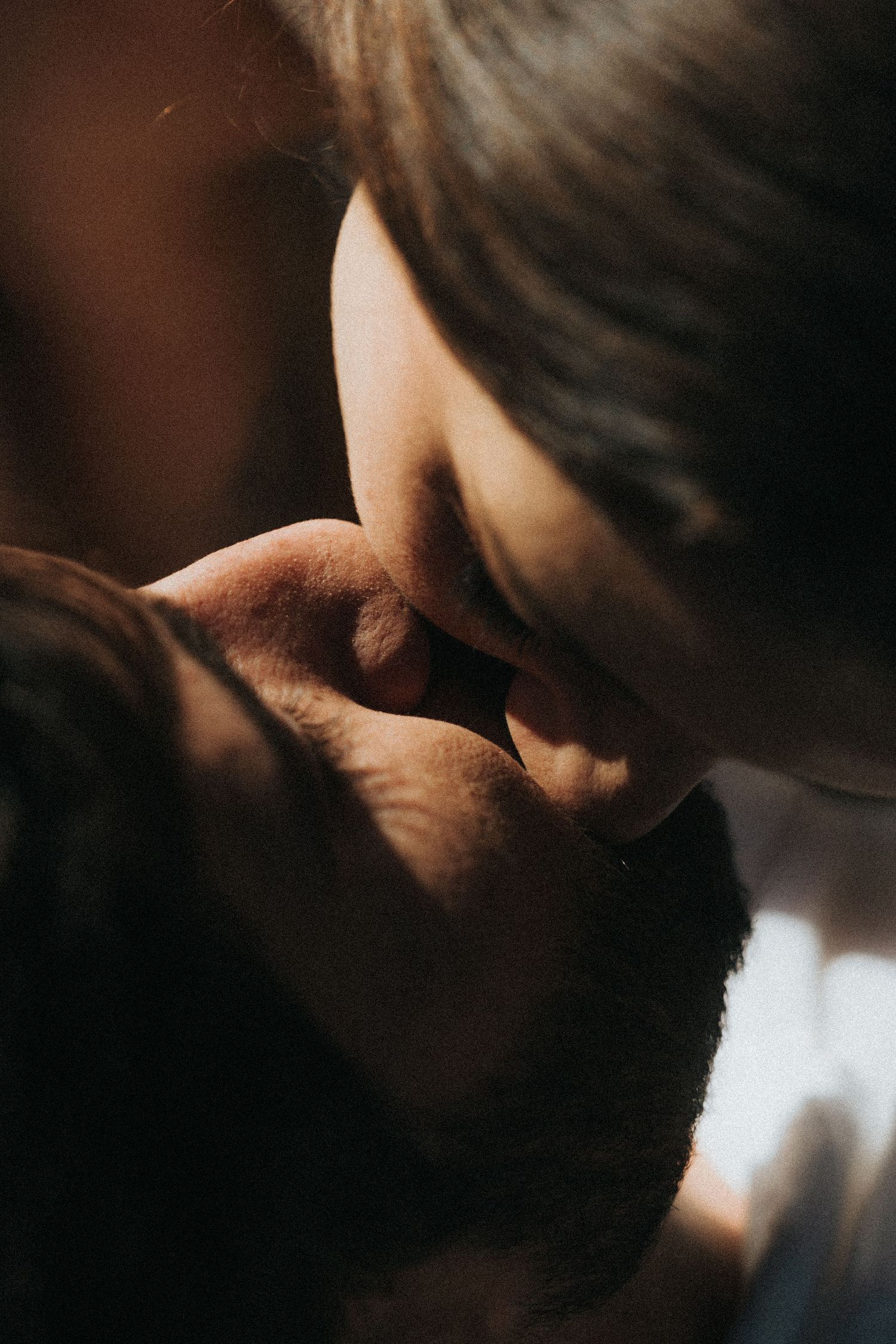A dark and moody close-up portrait sequence showing intimate details of someone's face in shadow.