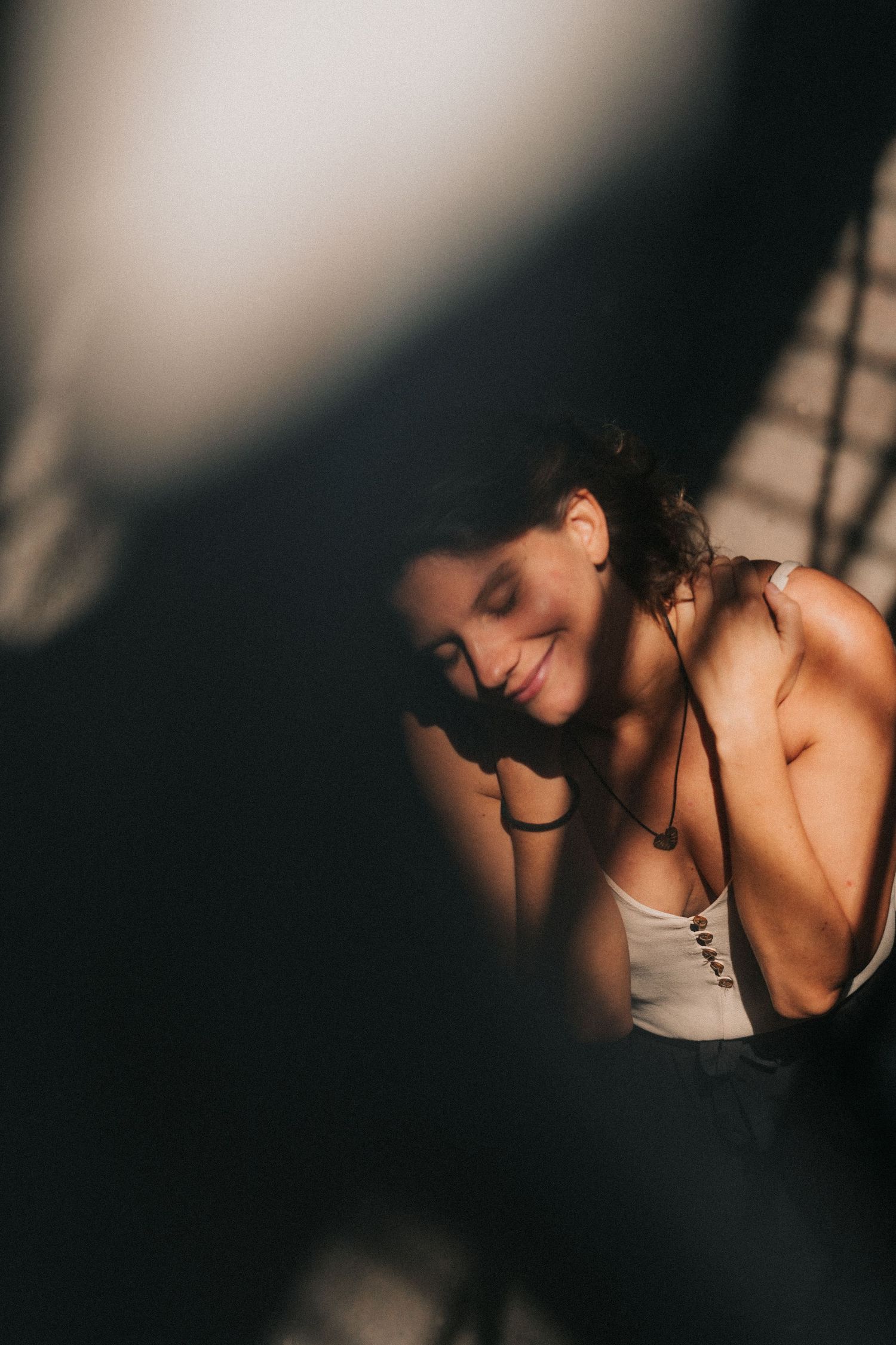 A soft, moody portrait series showing intimate shadows and dramatic lighting against a dark background.