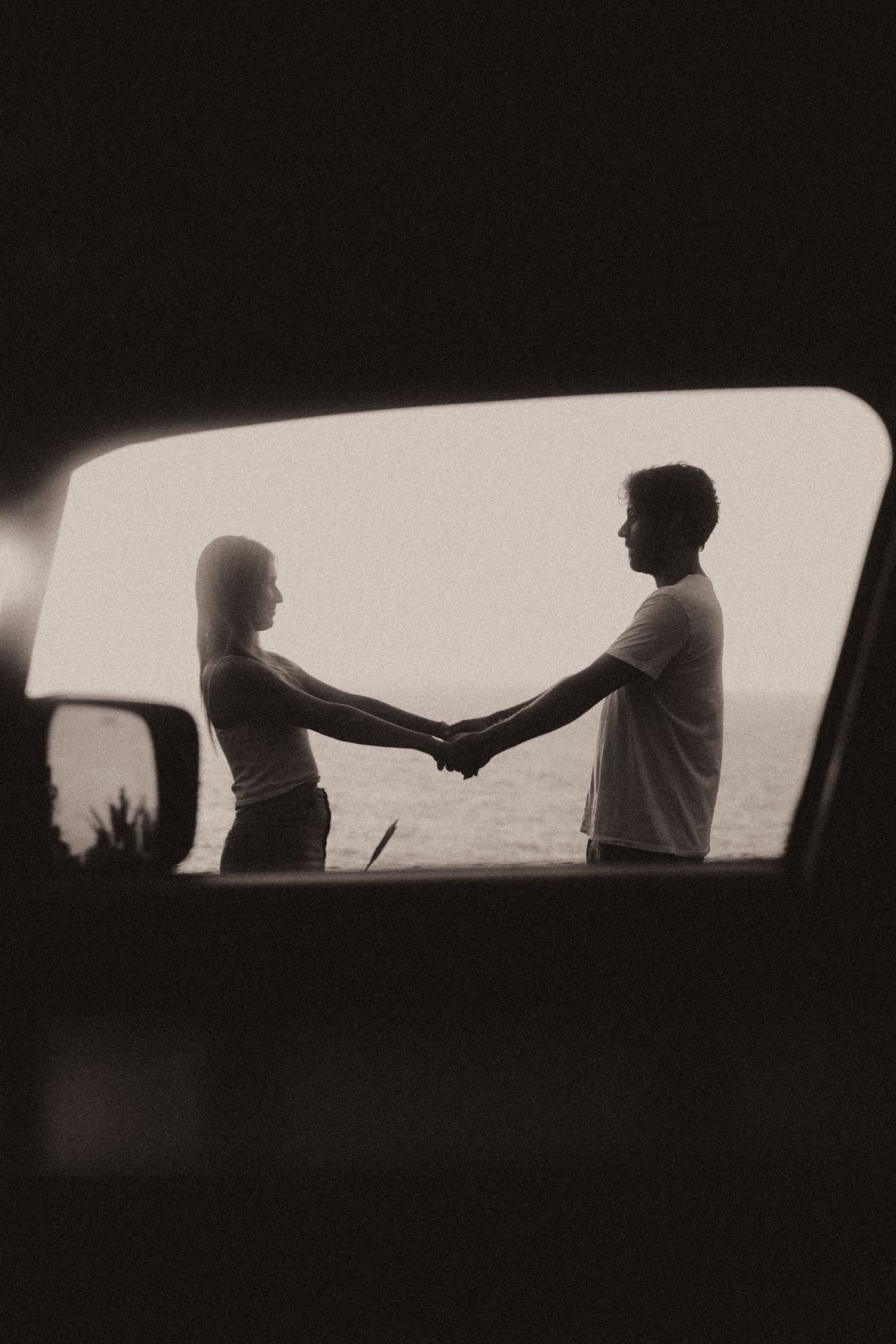 Black and white panoramic image showing silhouetted figures against car windows in a sequential artistic composition.