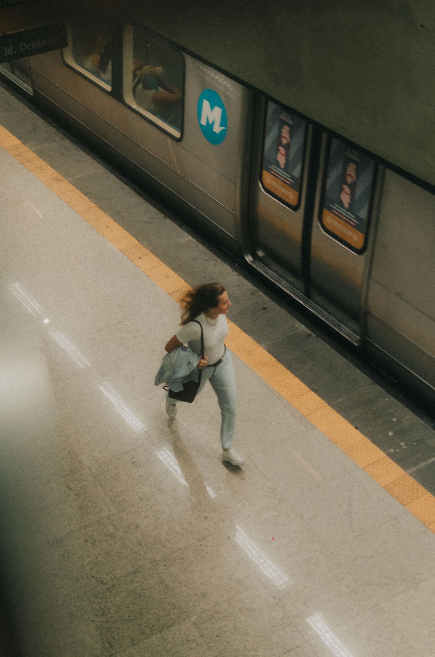 Person running and dancing down an empty subway platform in sequence, captured from above in four frames.