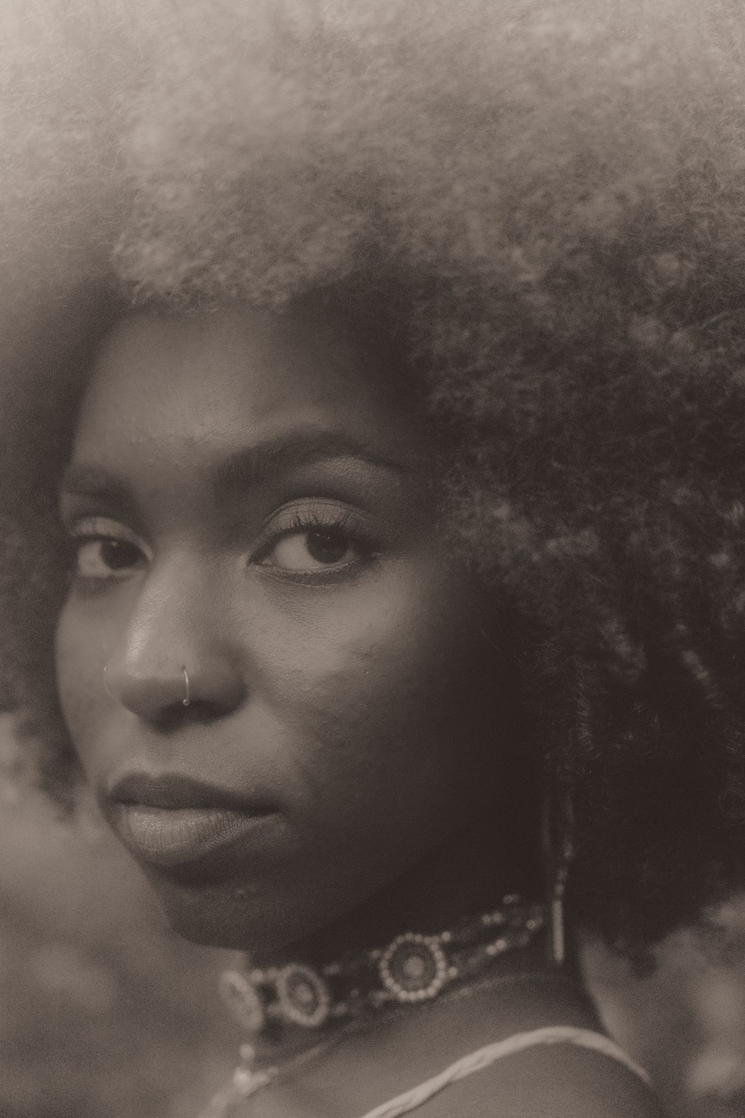 Black and white portrait series showing artistic close-up profile views with natural hair and expressive poses.