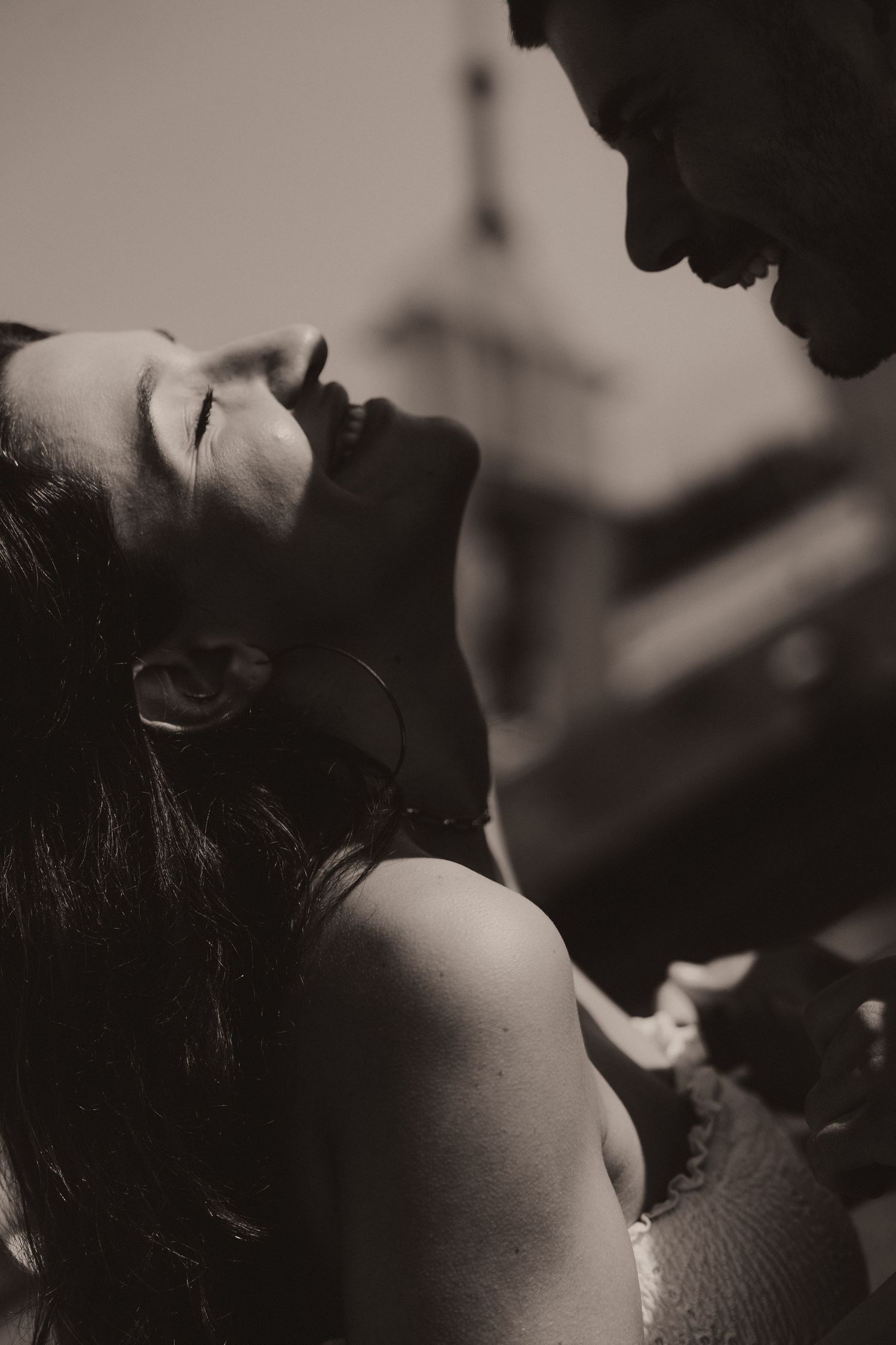 Black and white artistic photograph depicting intimate close-up portrait with dramatic shadows and lighting.