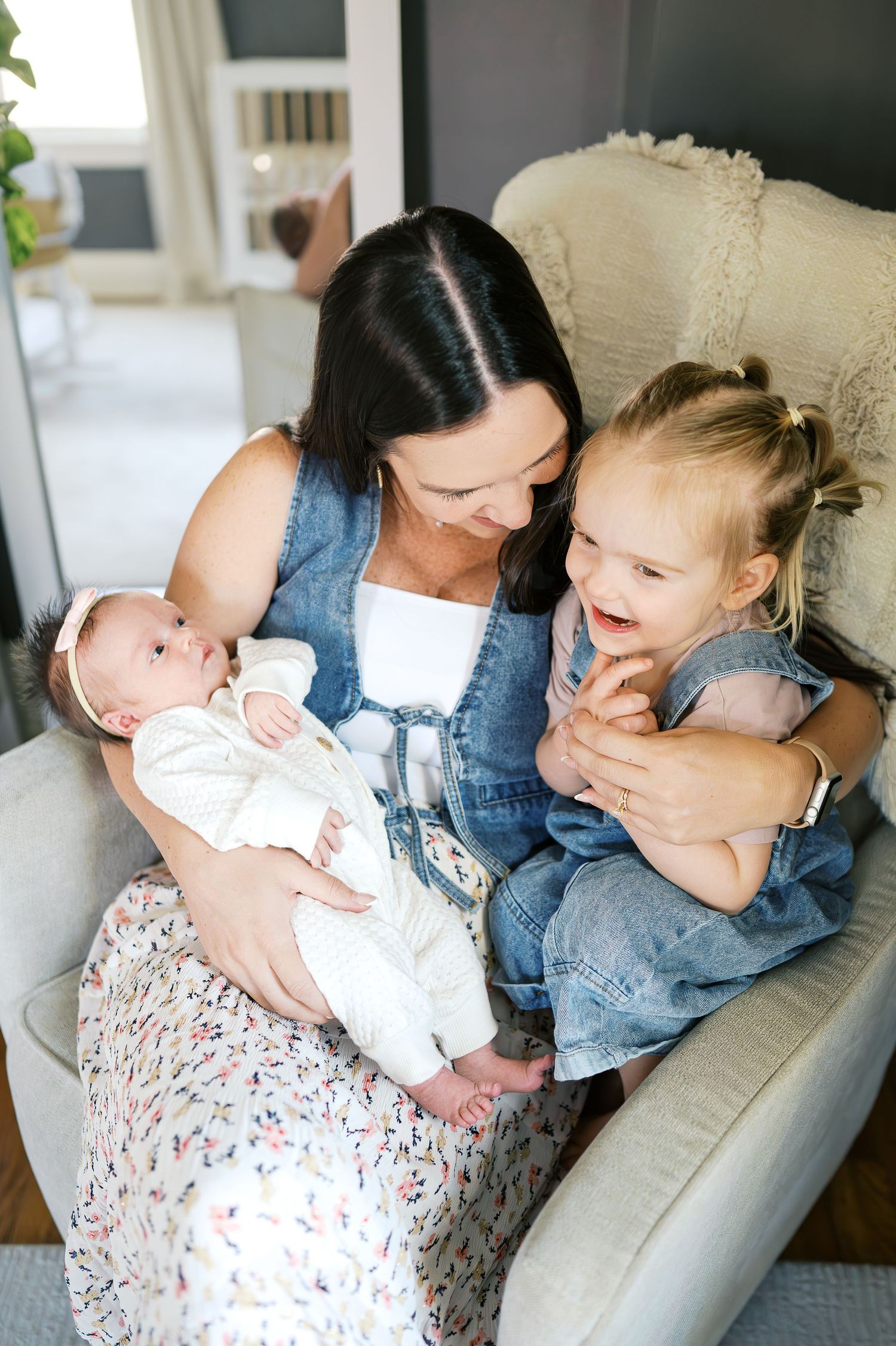 A joyful family moment shared in a comfortable armchair by a window.