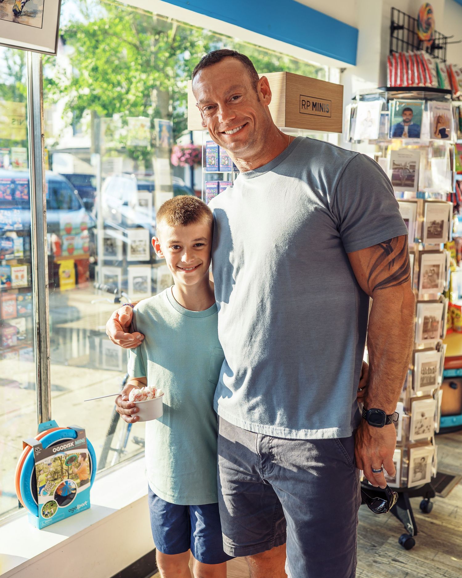 Customers posing together at an ice cream shop with retail displays in background.
