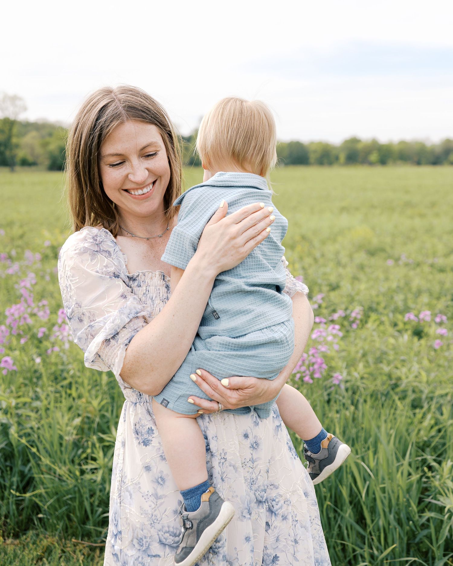 Tender family moments captured in a blooming spring field with soft natural light.