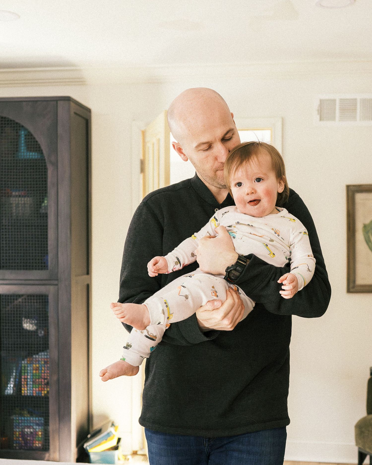 A tender moment of bonding in a cozy living room with dark cabinet decor.