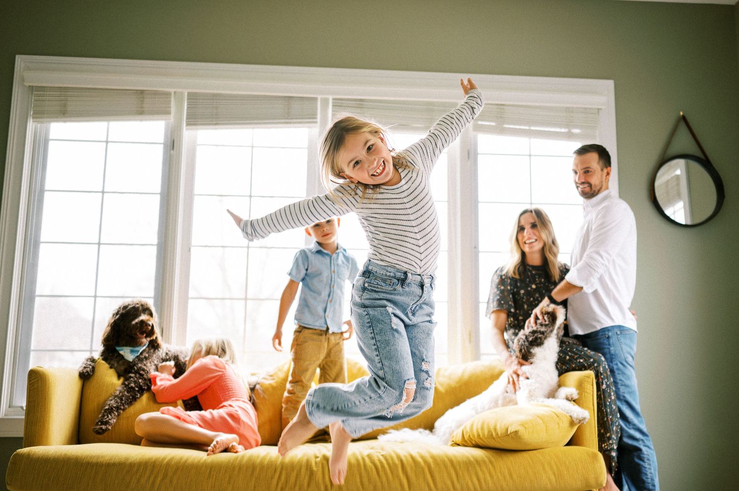 Energetic family playtime captured in a sequence of photos on a yellow couch.