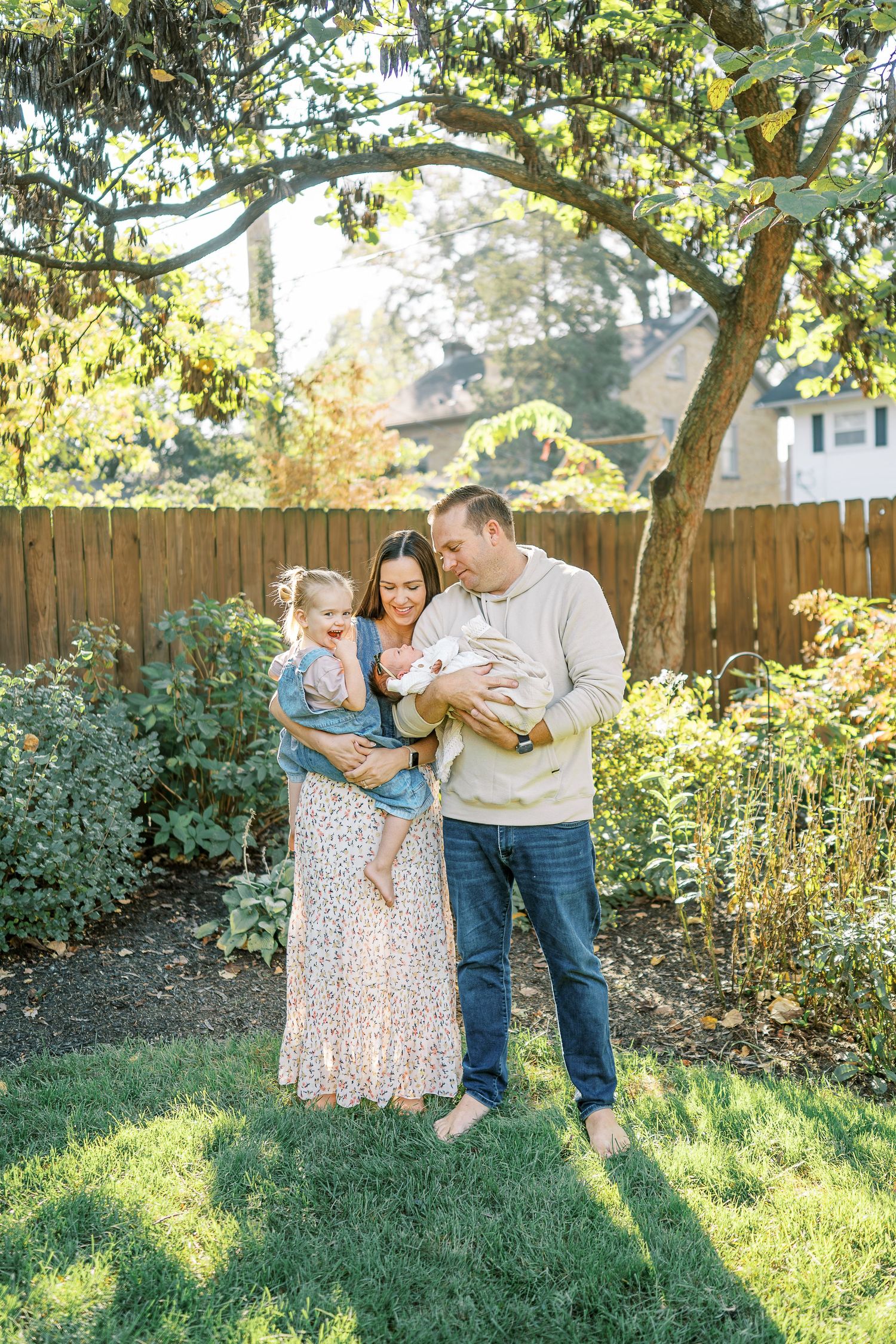A loving family spends time together in their fenced backyard on a sunny afternoon.