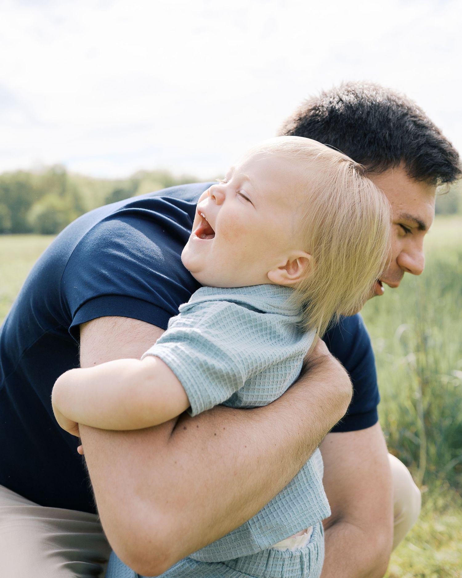 A heartwarming embrace between parent and child amid a sunny meadow.