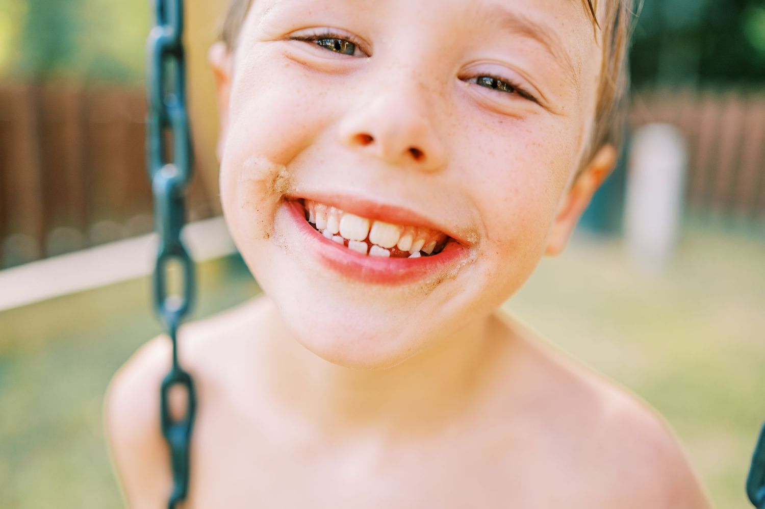 A joyful summer moment captured on a backyard swing set.