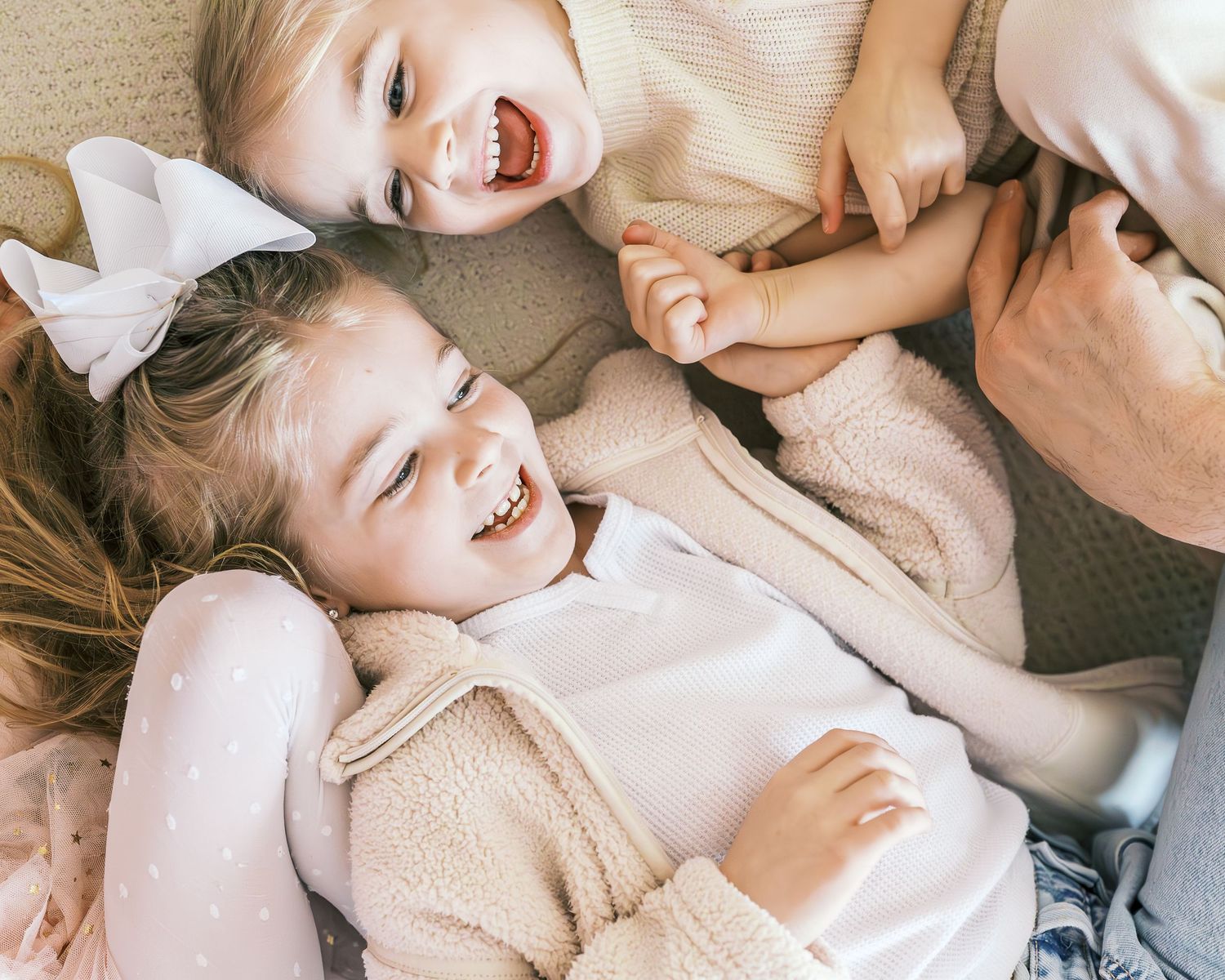 Playful interactions shown in soft beige tones on white bedding.