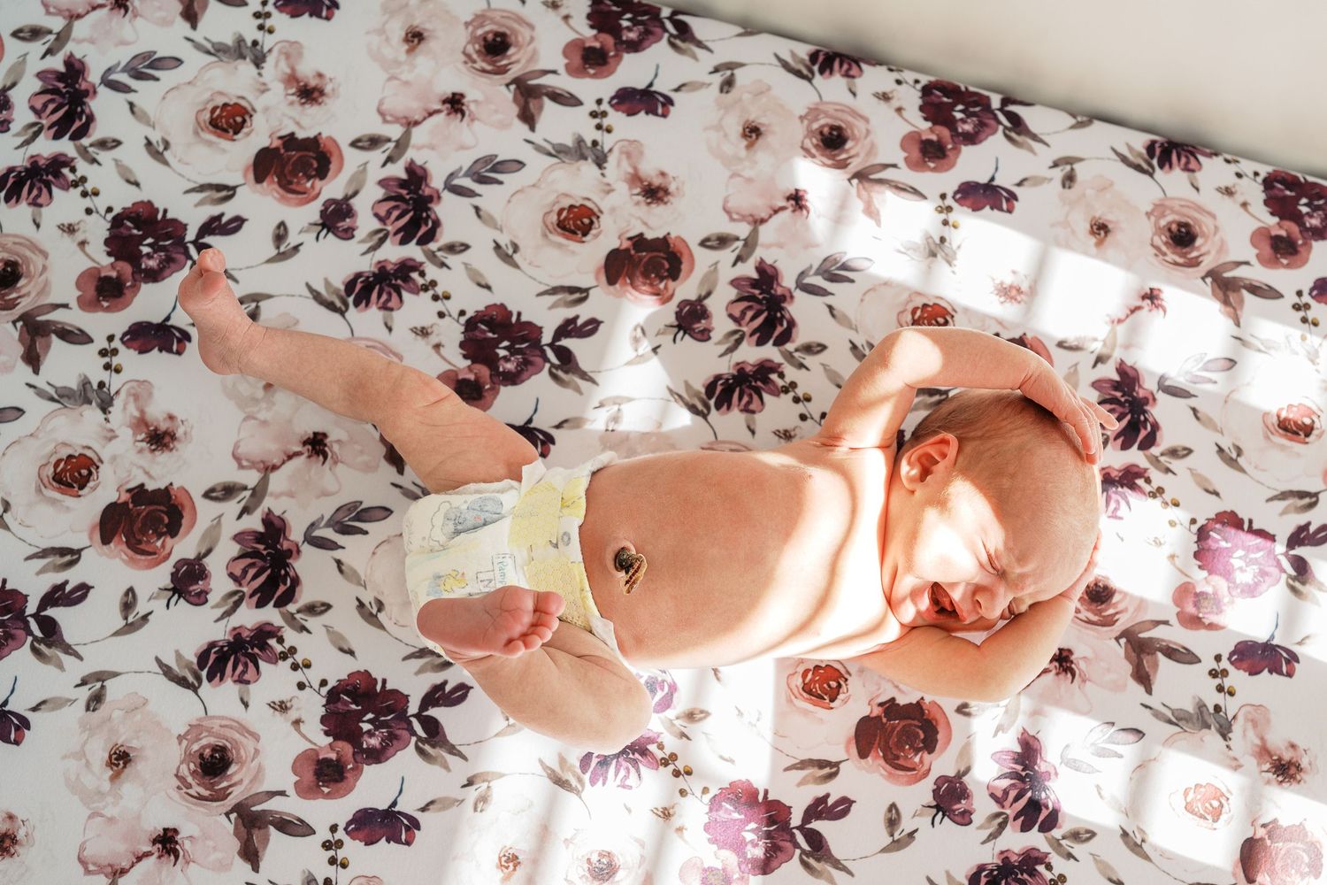 Baby lying on floral patterned fabric in a series of artistic overhead shots.