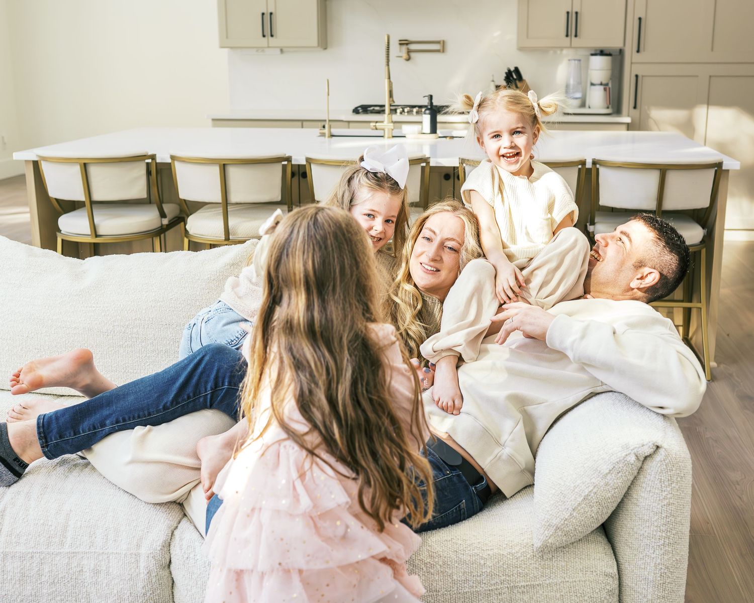 Lifestyle photography capturing intimate family moments on a white sofa.