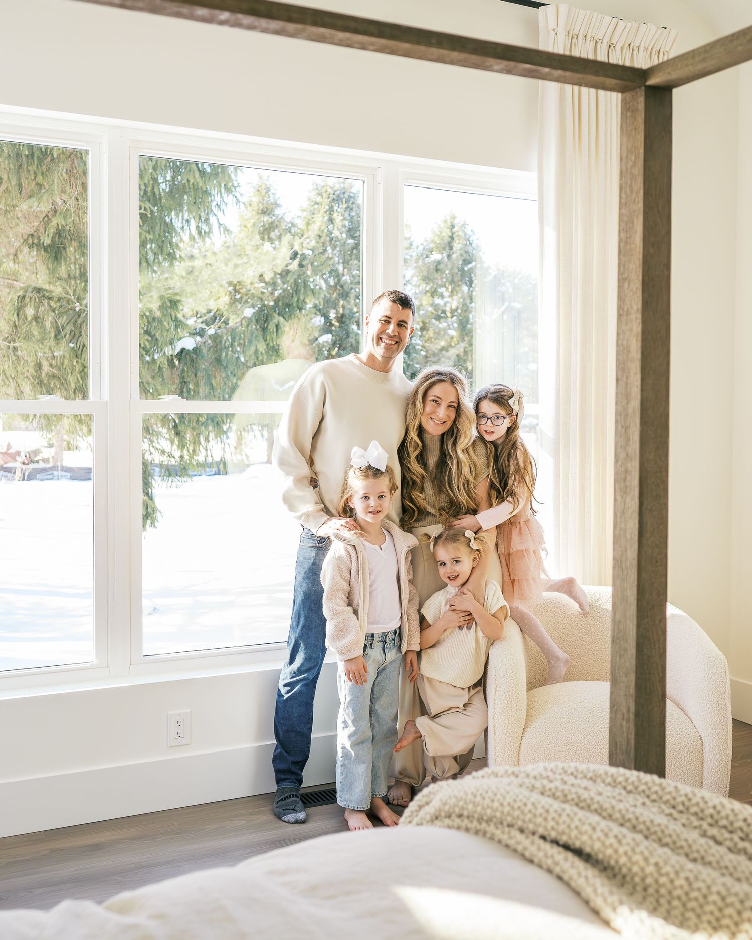 Happy family spending time together in bright empty room with large windows.