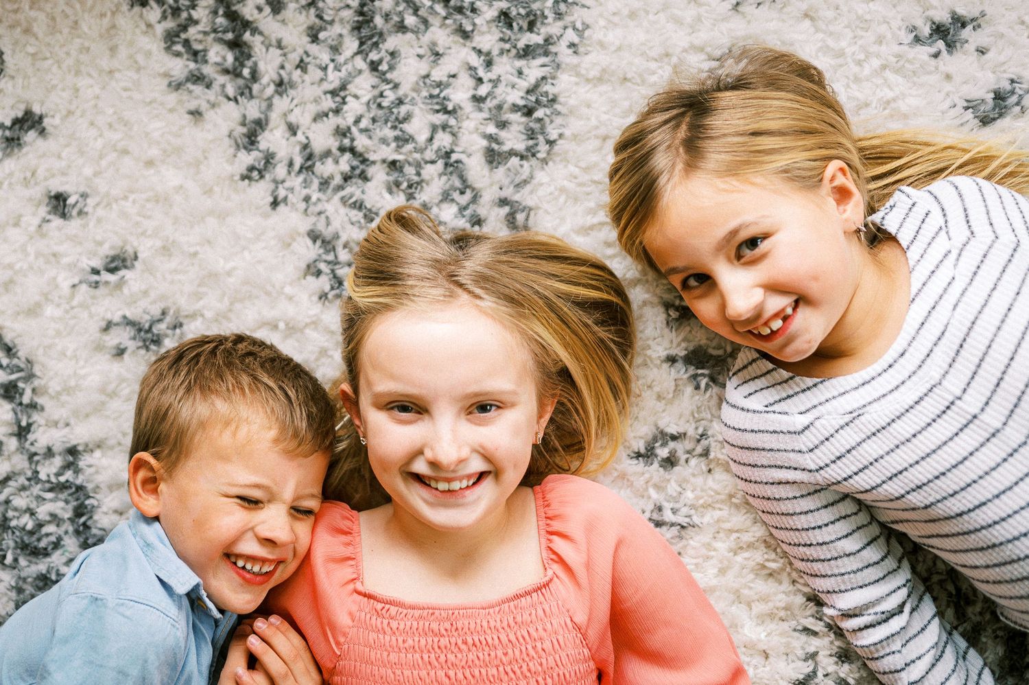 Close-up of joyful expressions against a textured gray background.