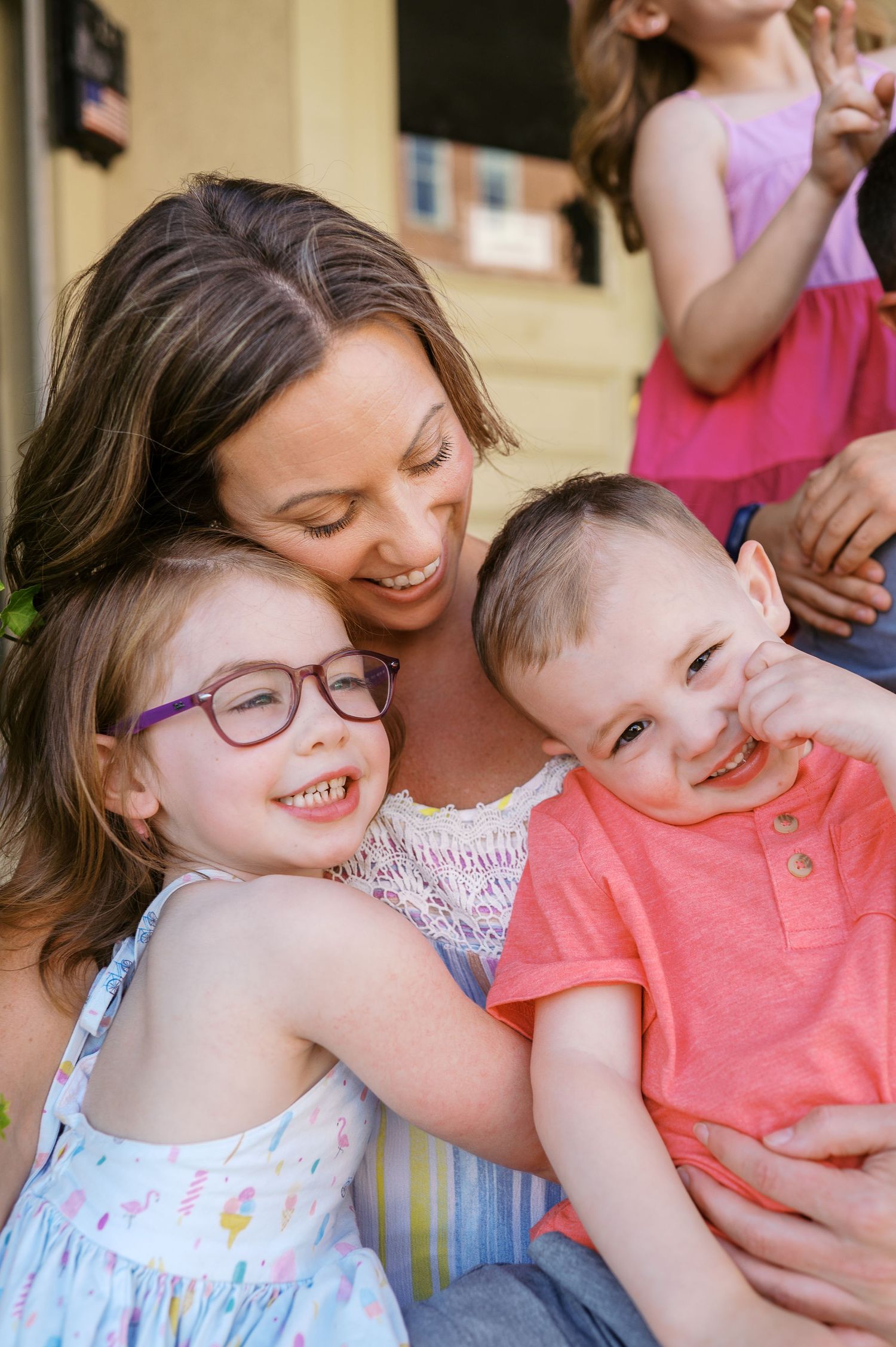 A joyful moment captured between family members sharing laughter and hugs on a sunny day.