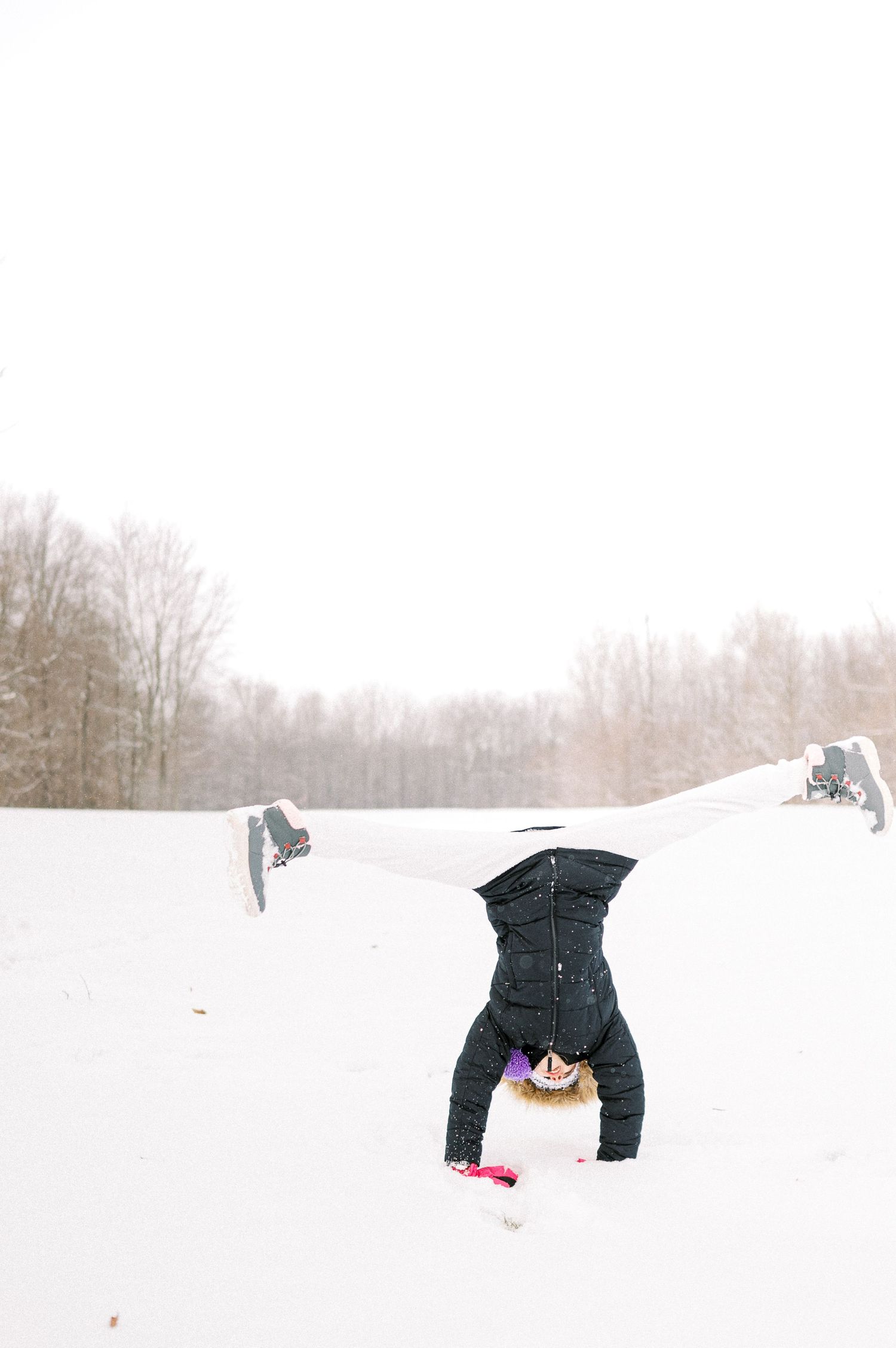 A series of playful headstands and flips in fresh white snow.