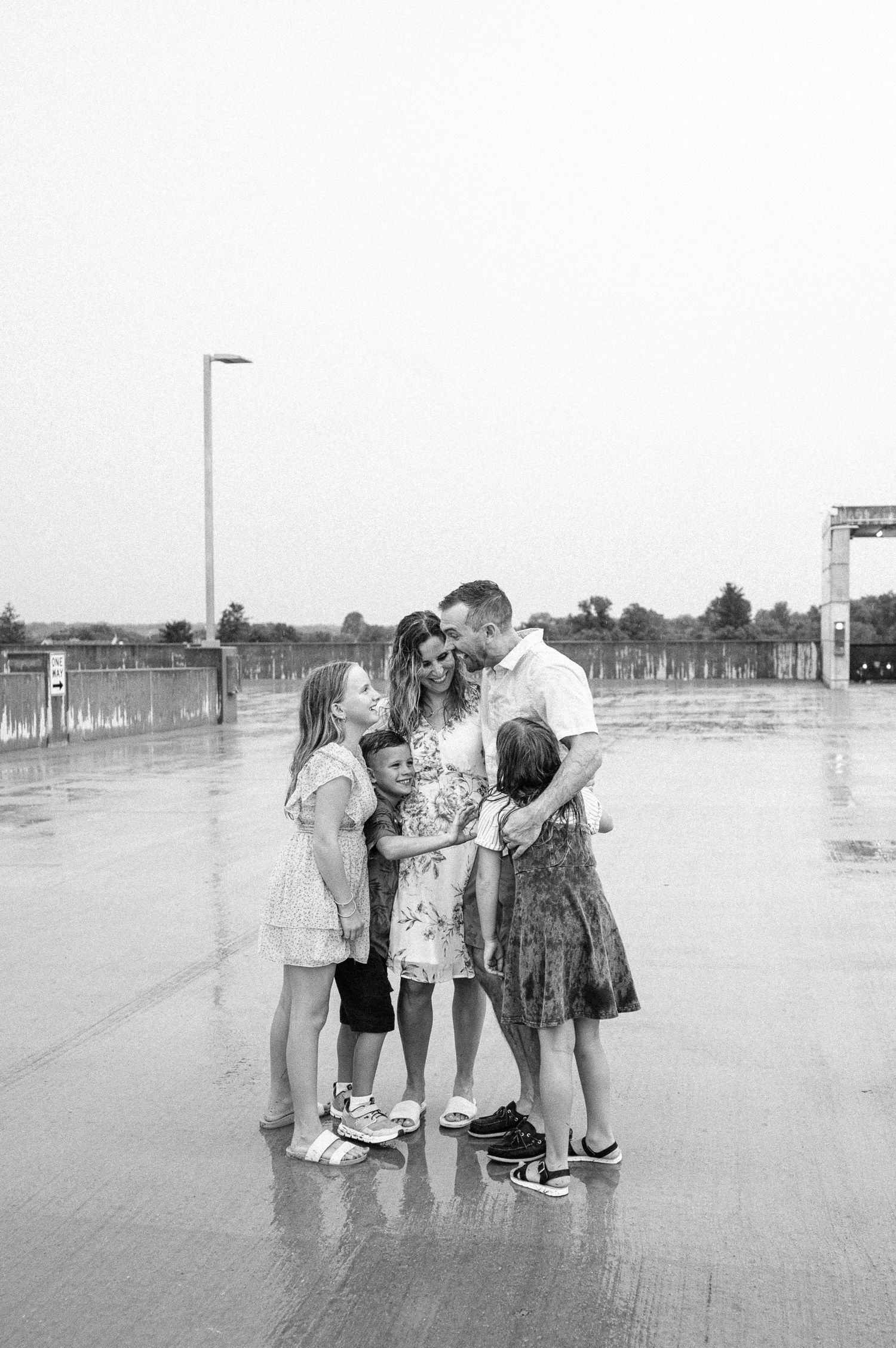 People embrace on a misty beach boardwalk during an overcast day.