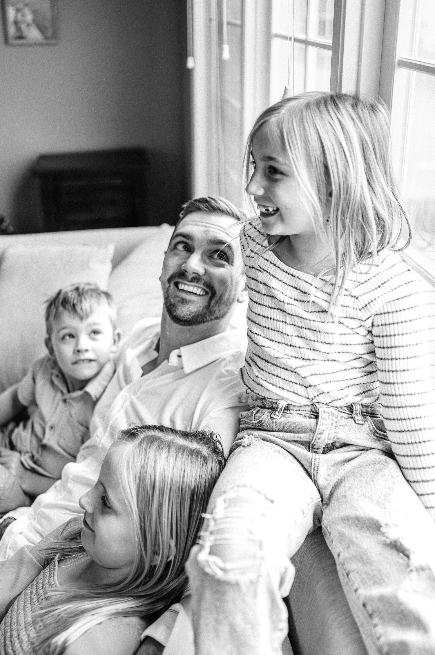 Black and white candid photo of family members sharing joyful moments together.